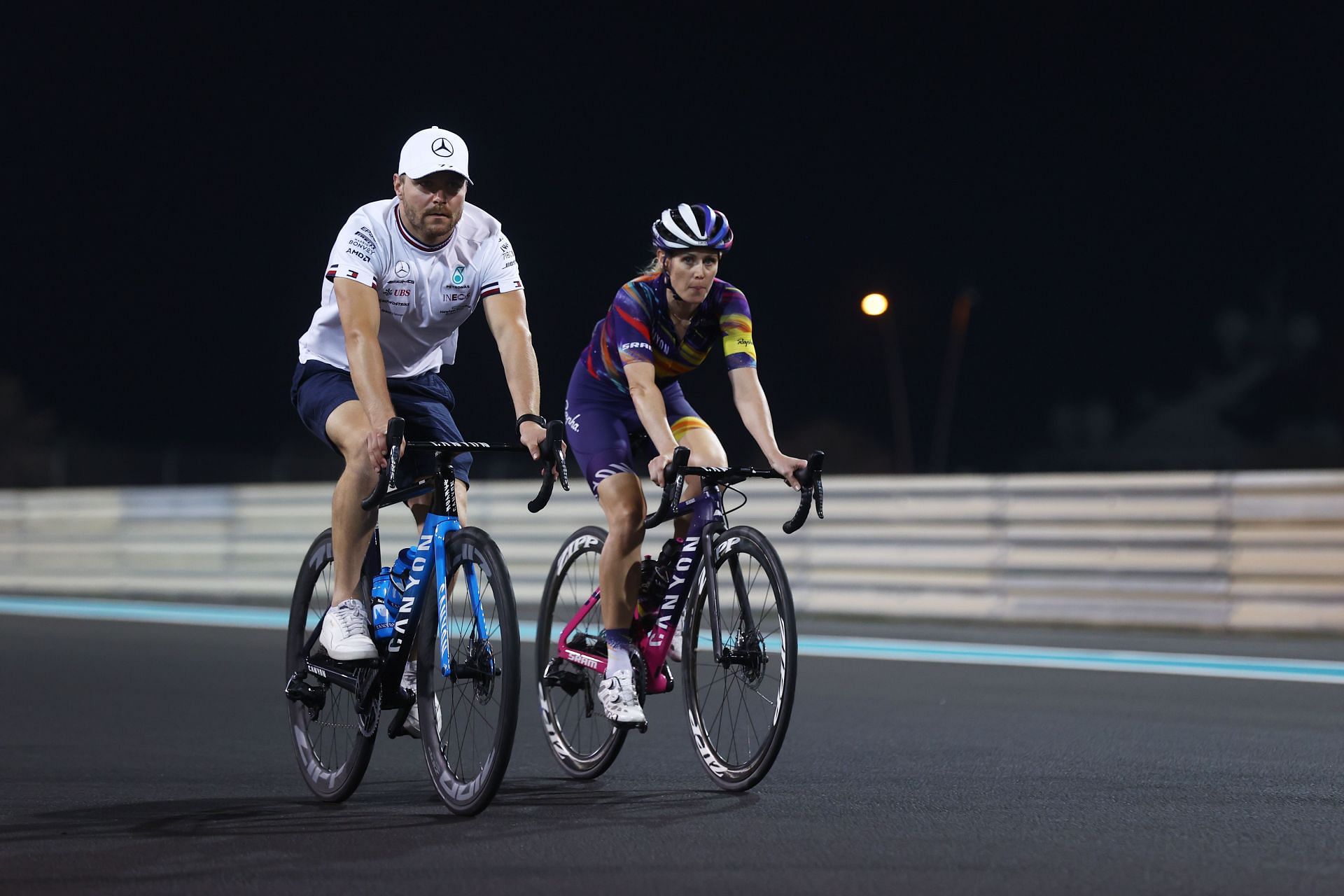 Valtteri Bottas cycles the track with his girlfriend, cyclist Tiffany Cromwell, at the Yas Marina