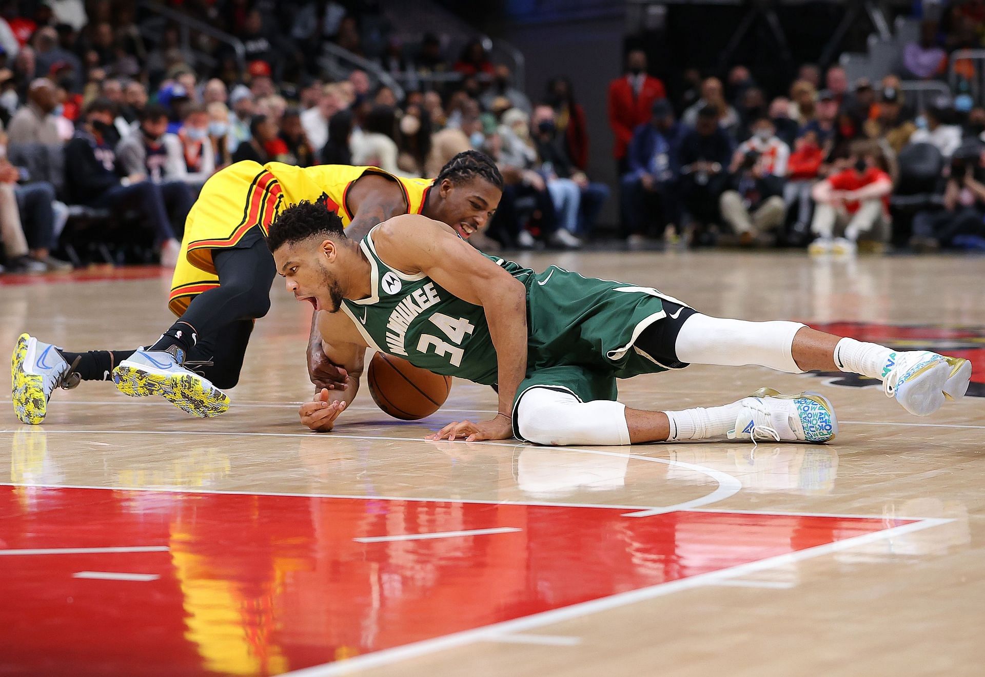 Giannis Antetokounmpo dives to save the ball.