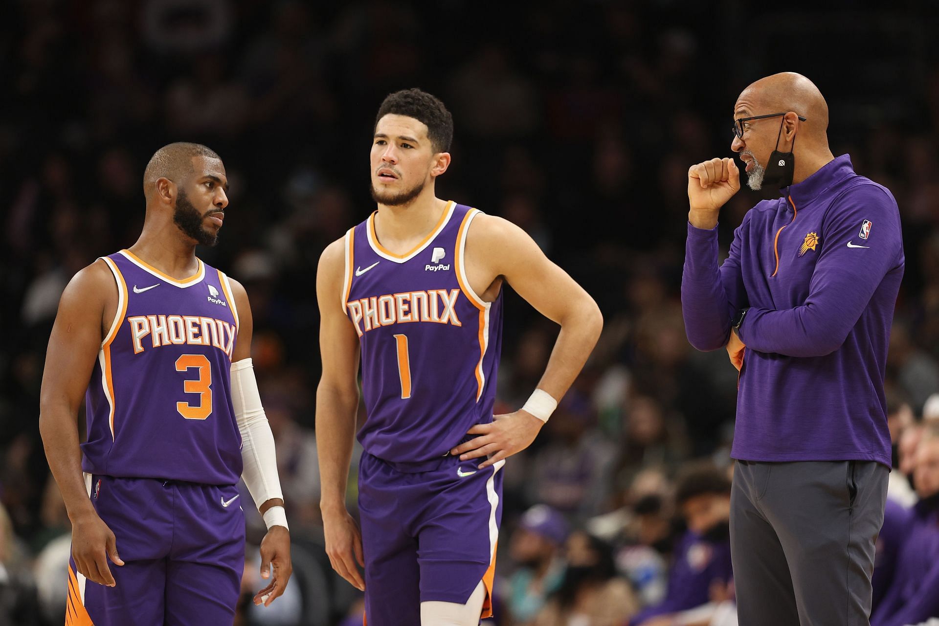 Coach Monty Williams of the Phoenix Suns talks with Chris Paul (3) and Devin Booker.