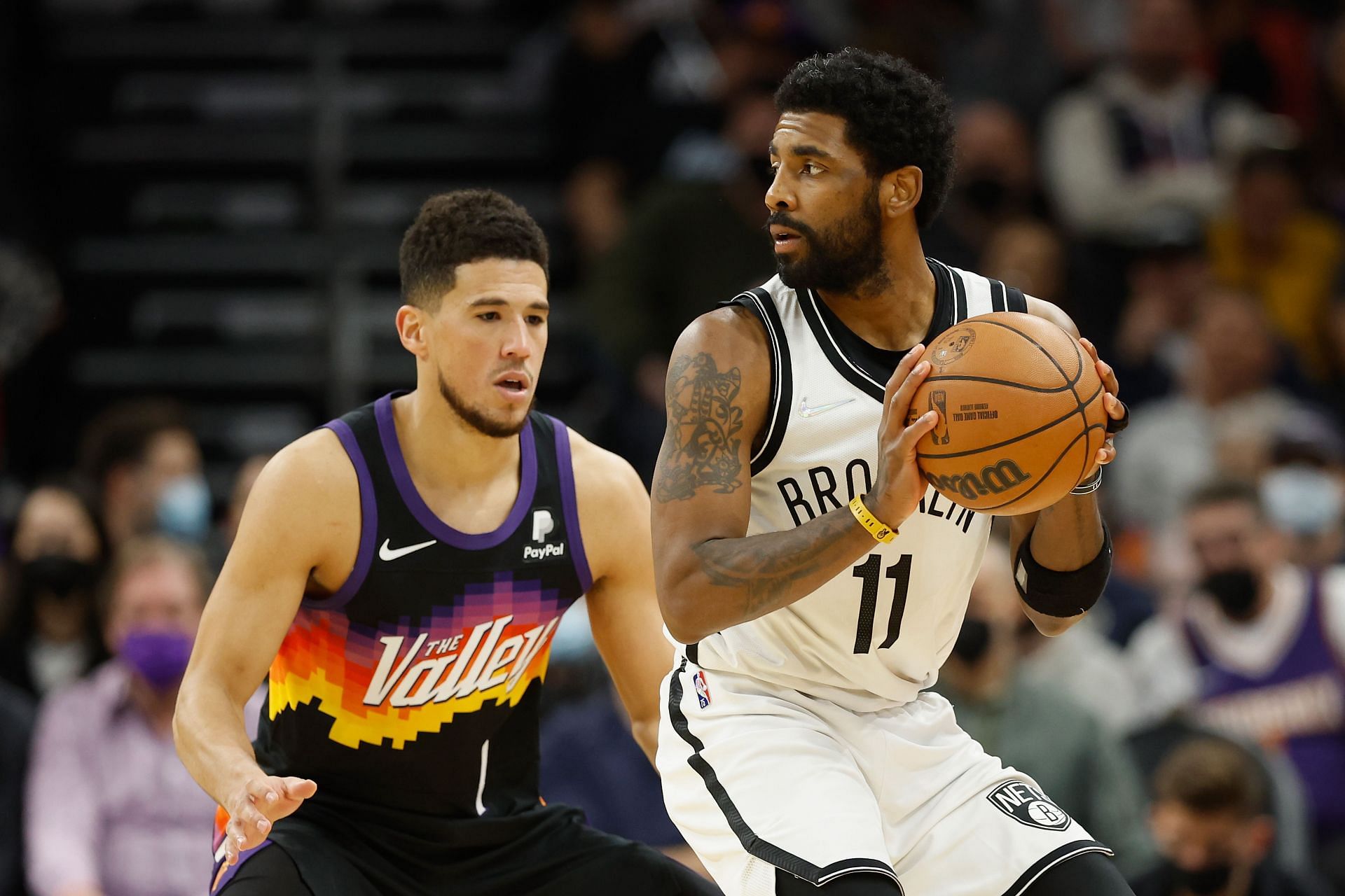 Kyrie Irving of the Brooklyn Nets handles the ball against Devin Booker of the Phoenix Suns on Wednesday in Phoenix, Arizona.