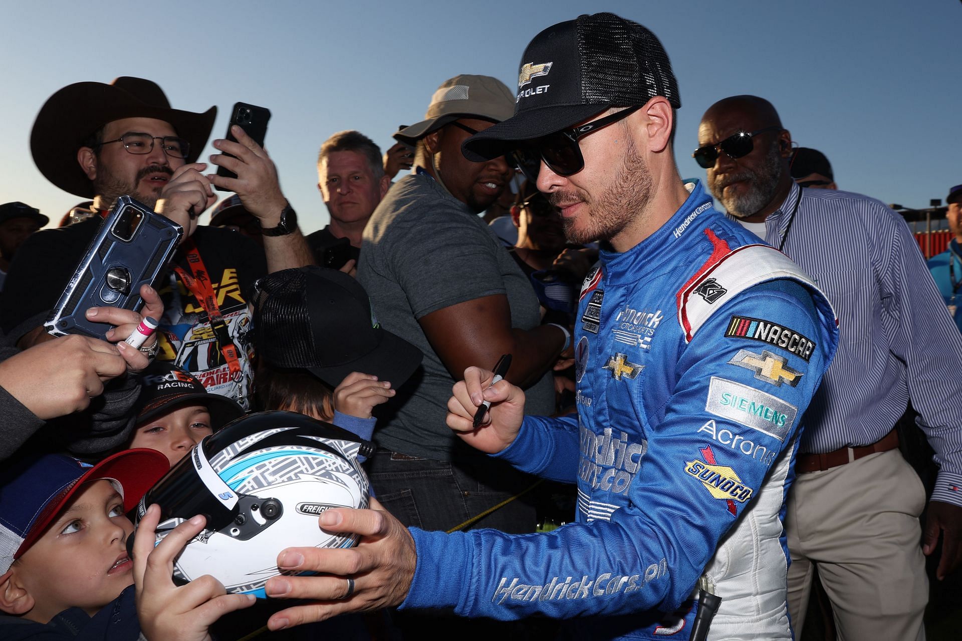 Kyle Larson signs autographs for fans after winning the WISE Power 400 at Auto Club Speedway