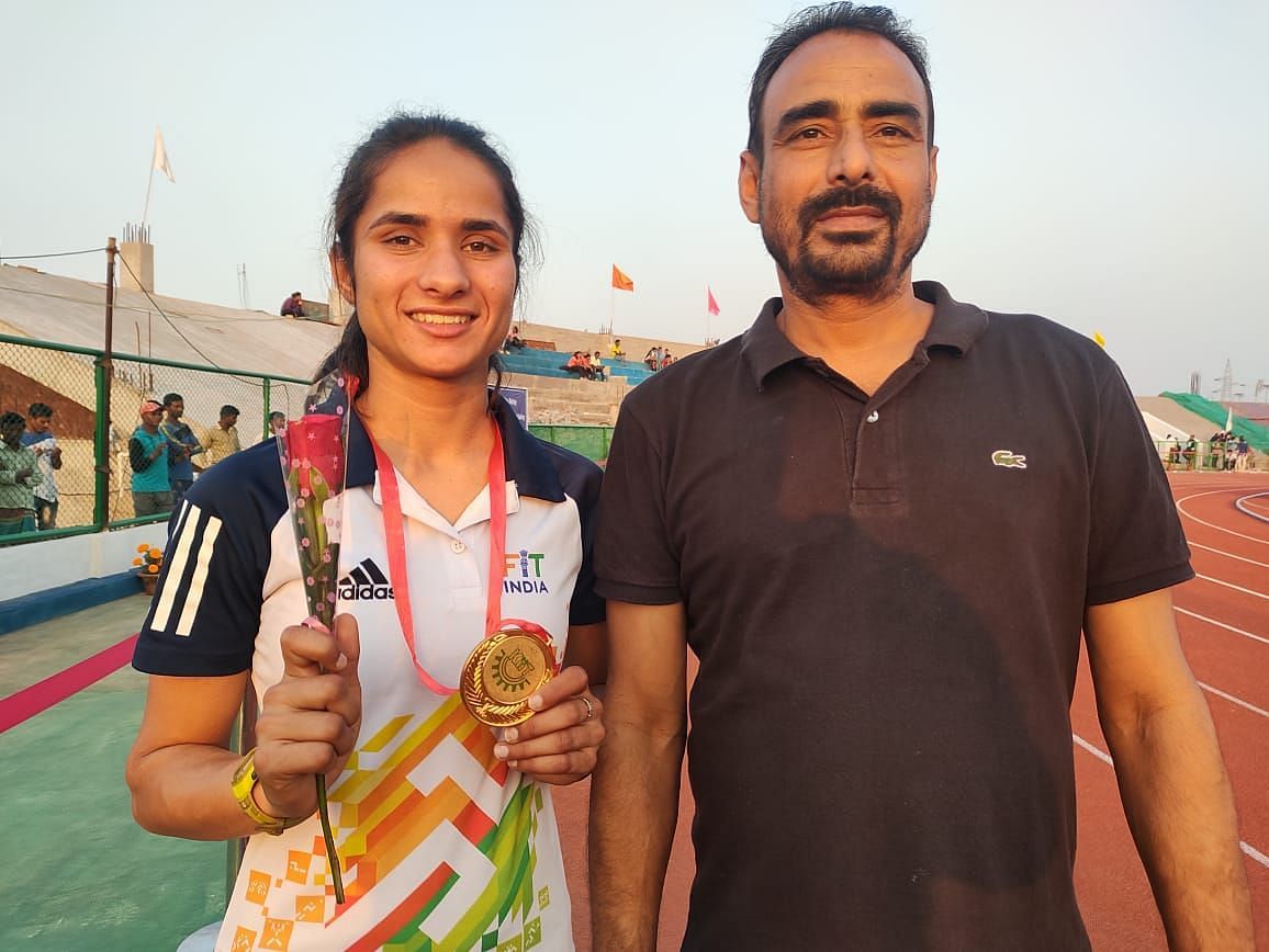 Newly-crowned champion Baljeet Kaur with her coach Gurdev Singh after winning gold medal in the women&#039;s 20km race walk event at the All India Inter University Athletics Championships