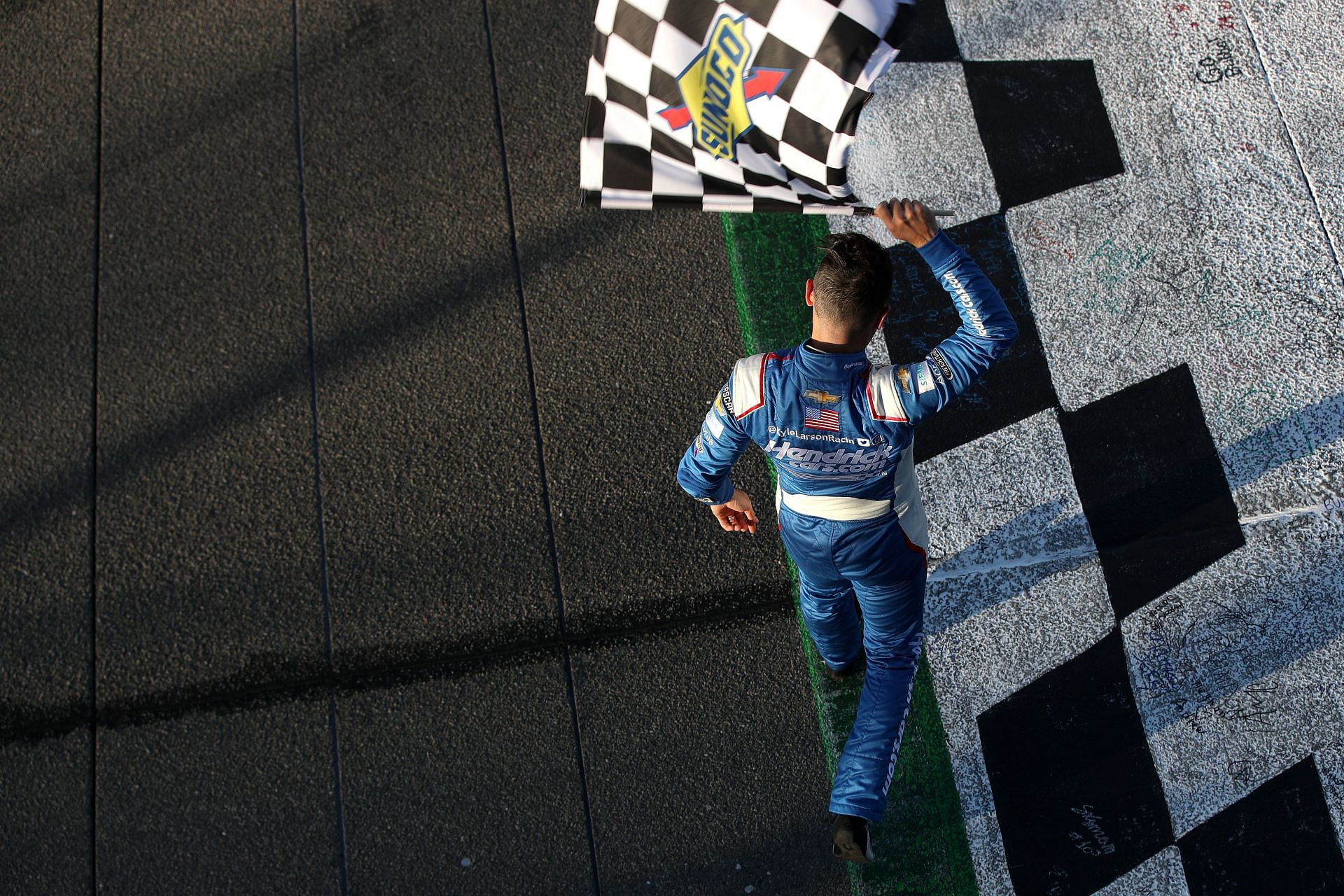 Kyle Larson celebrates with the checkered flag after winning the Wise Power 400 at Auto Club Speedway