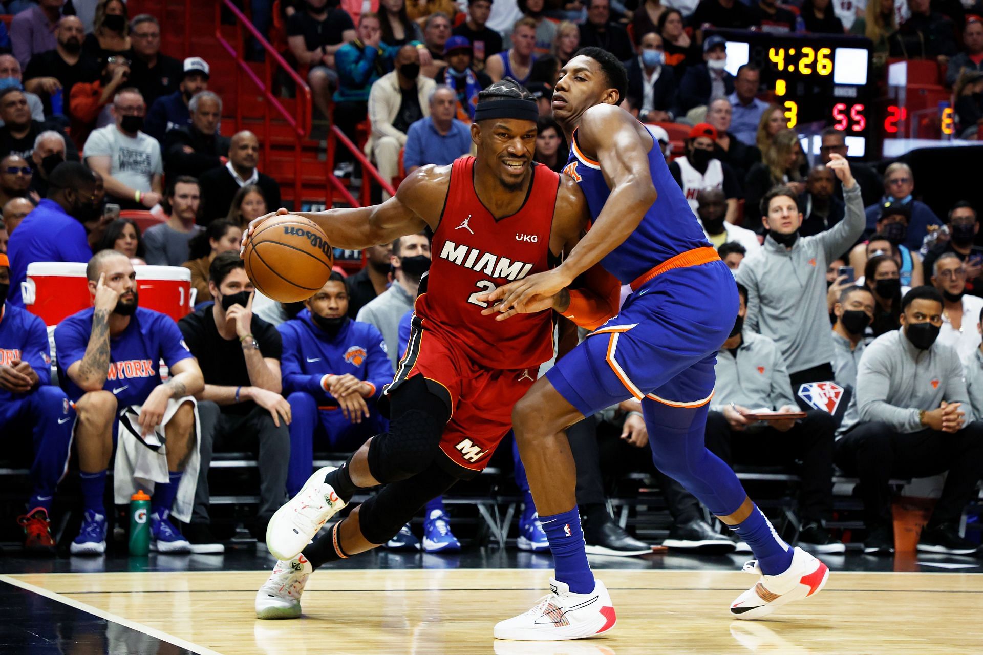 Jimmy Butler #22 of the Miami Heat drives against RJ Barrett #9 of the New York Knicks.