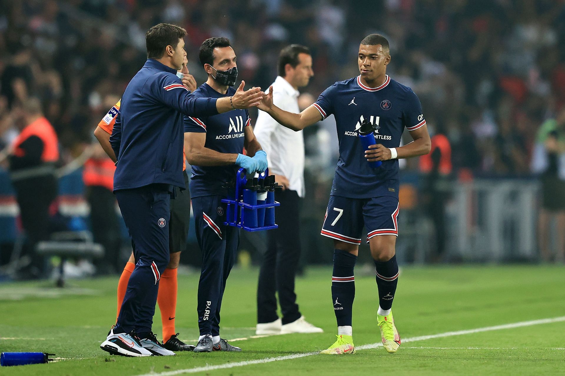 Mauricio Pochettino (left) greets Kylian Mbappe (right) during a league game.