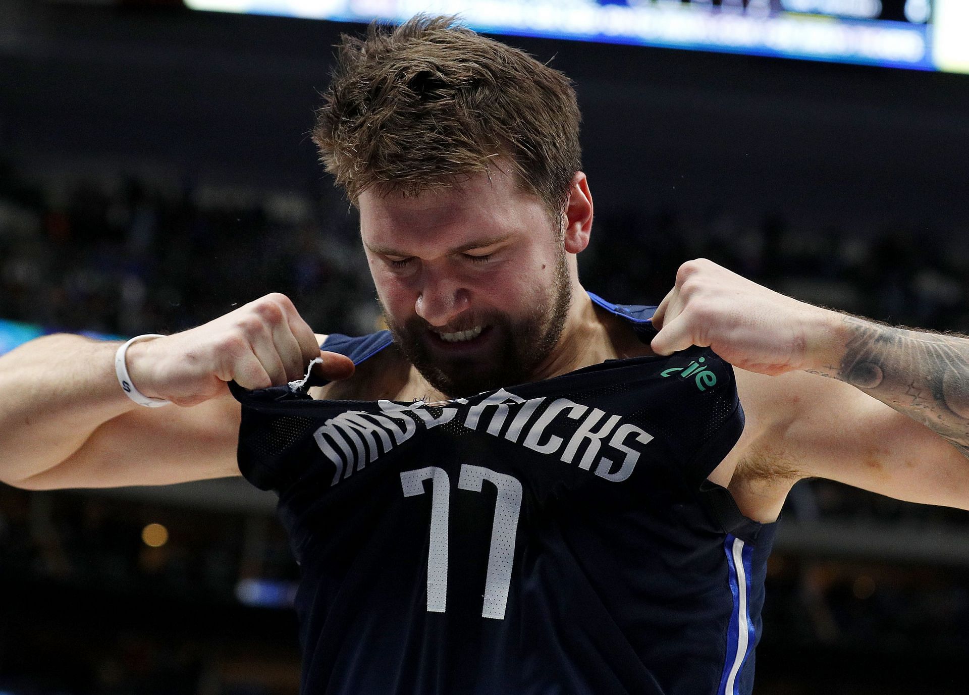 Luka Doncic of the Dallas Mavericks rips his jersey as he walks off the court