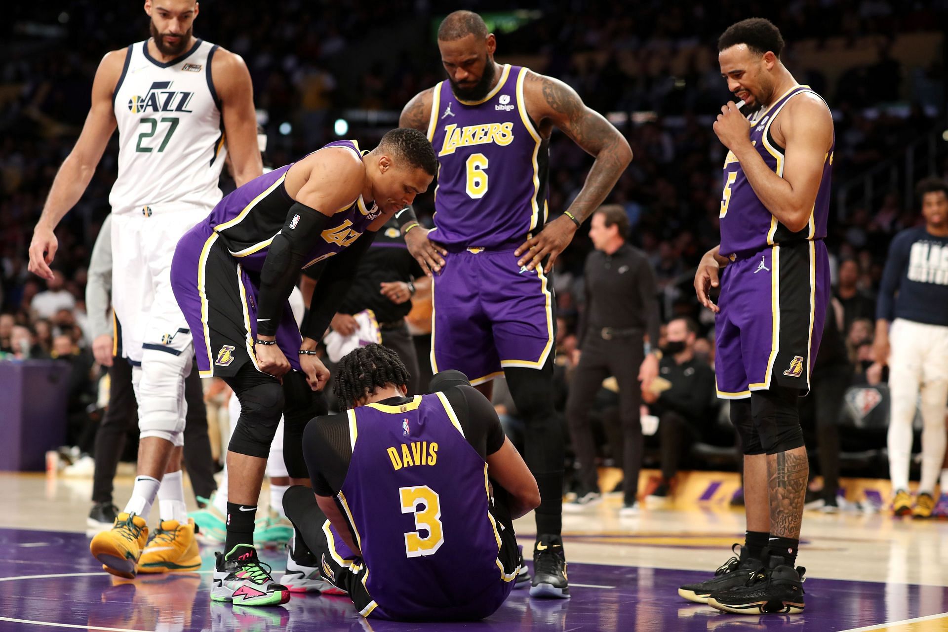Russell Westbrook (left), LeBron James (6) and Talen Horton-Tucker (right) of the LA Lakers check on teammate Anthony Davis after an injury during the second quarter against the Utah Jazz on Feb. 16, 2022, in Los Angeles, California.
