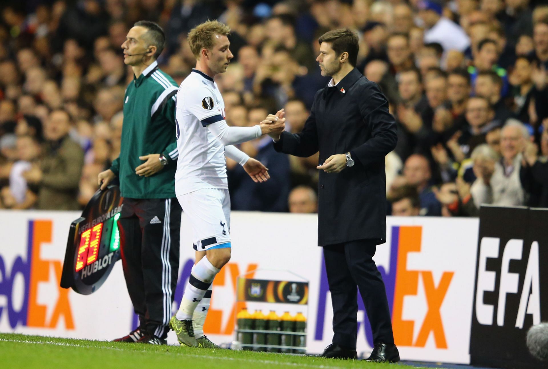 Christian Eriksen (left) greets Mauricio Pochettino after being subbed off.