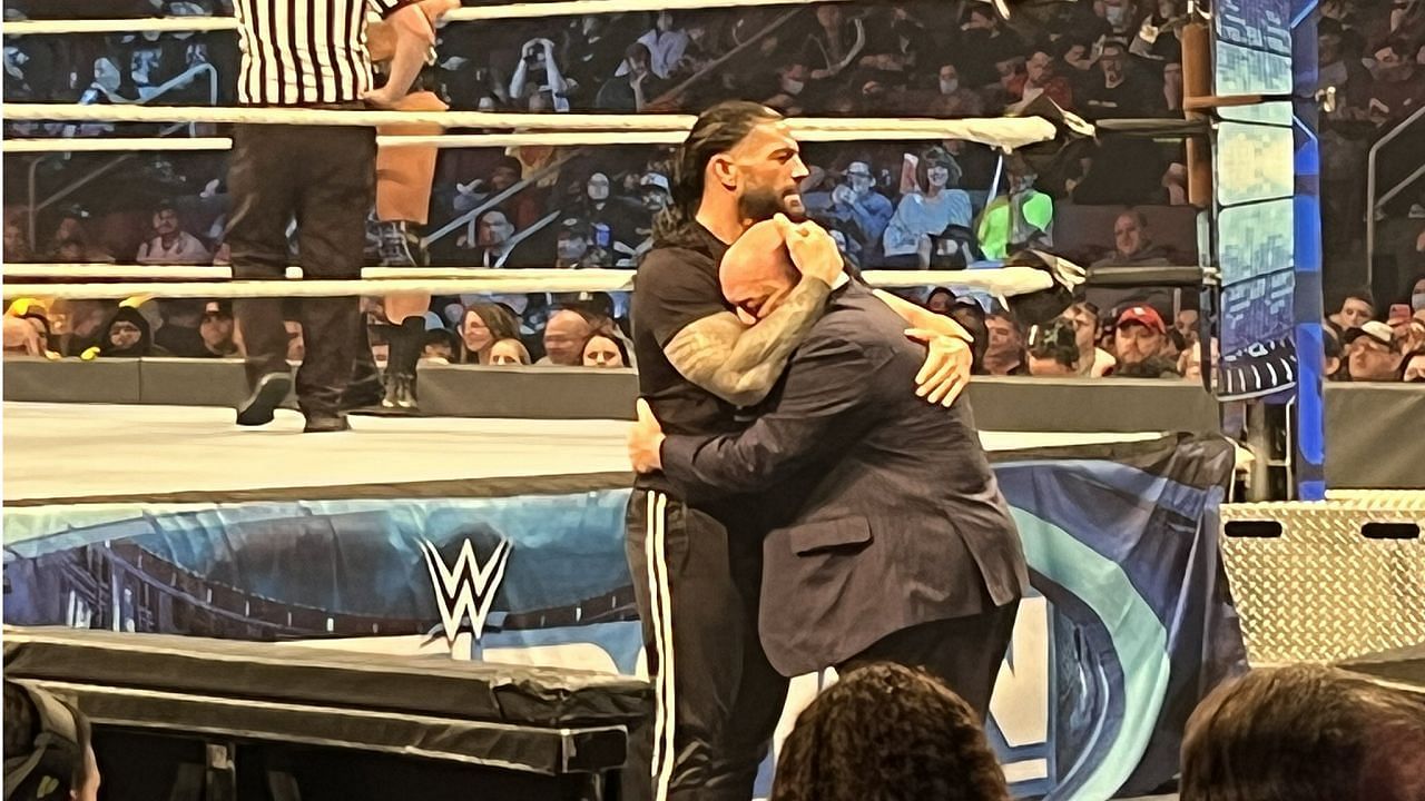 Reigns and Paul Heyman embrace at ringside