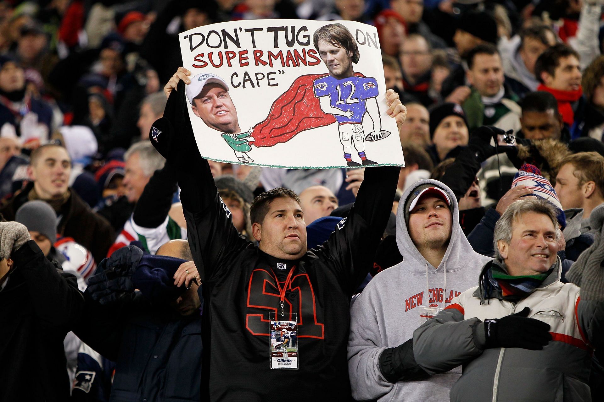 Patriots fan holding a sign with Rex Ryan and &quot;Superman&quot; Brady
