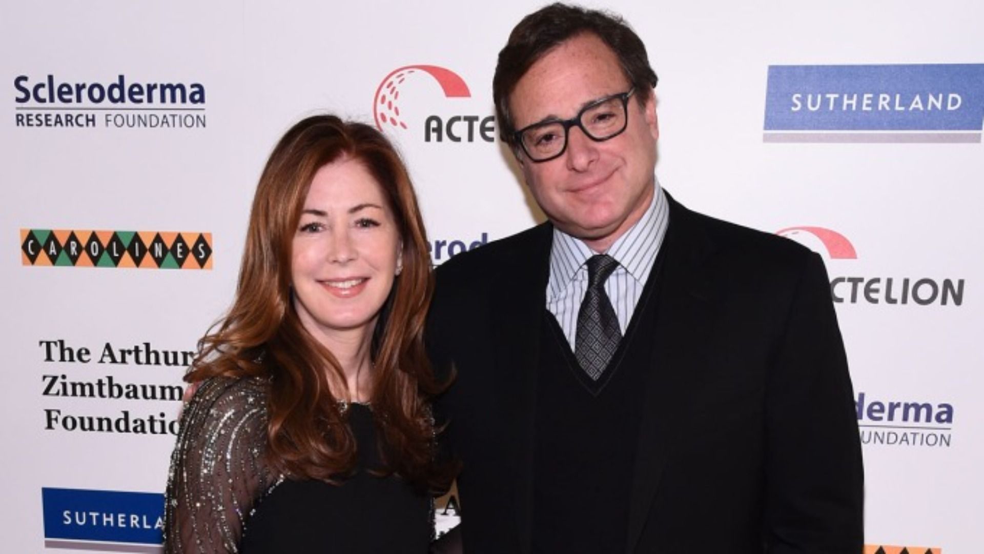 Dana Delany and Bob Saget posing for paparazzi (Image via Getty Images/Ilya S. Savenok)