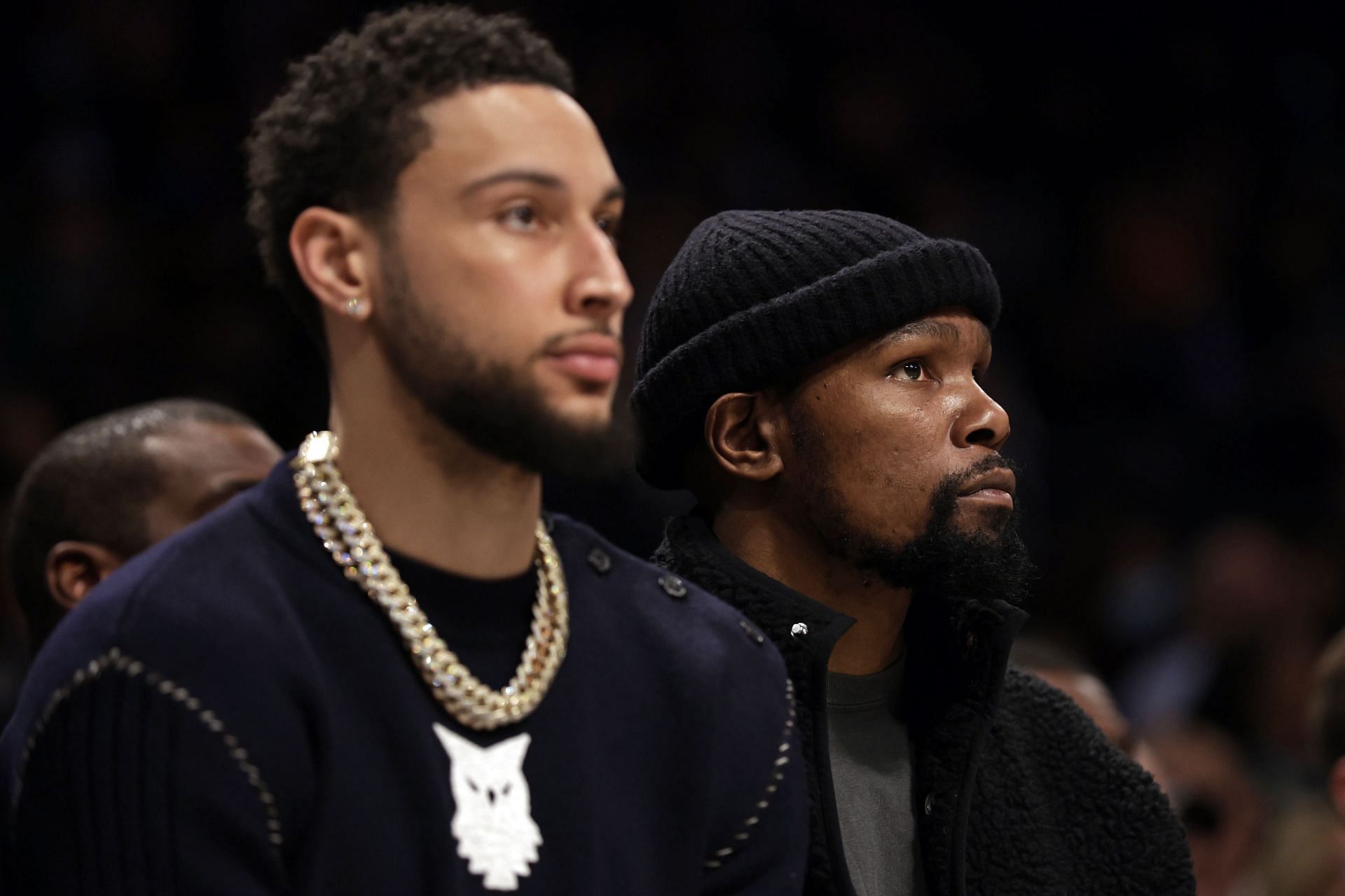 Kevin Durant (R) of the Brooklyn Nets looks on from the bench next to Ben Simmons (L)