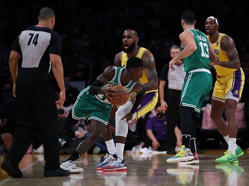 Denis Schroder of the Boston Celtics (R) guarded by LeBron James of the LA Lakers