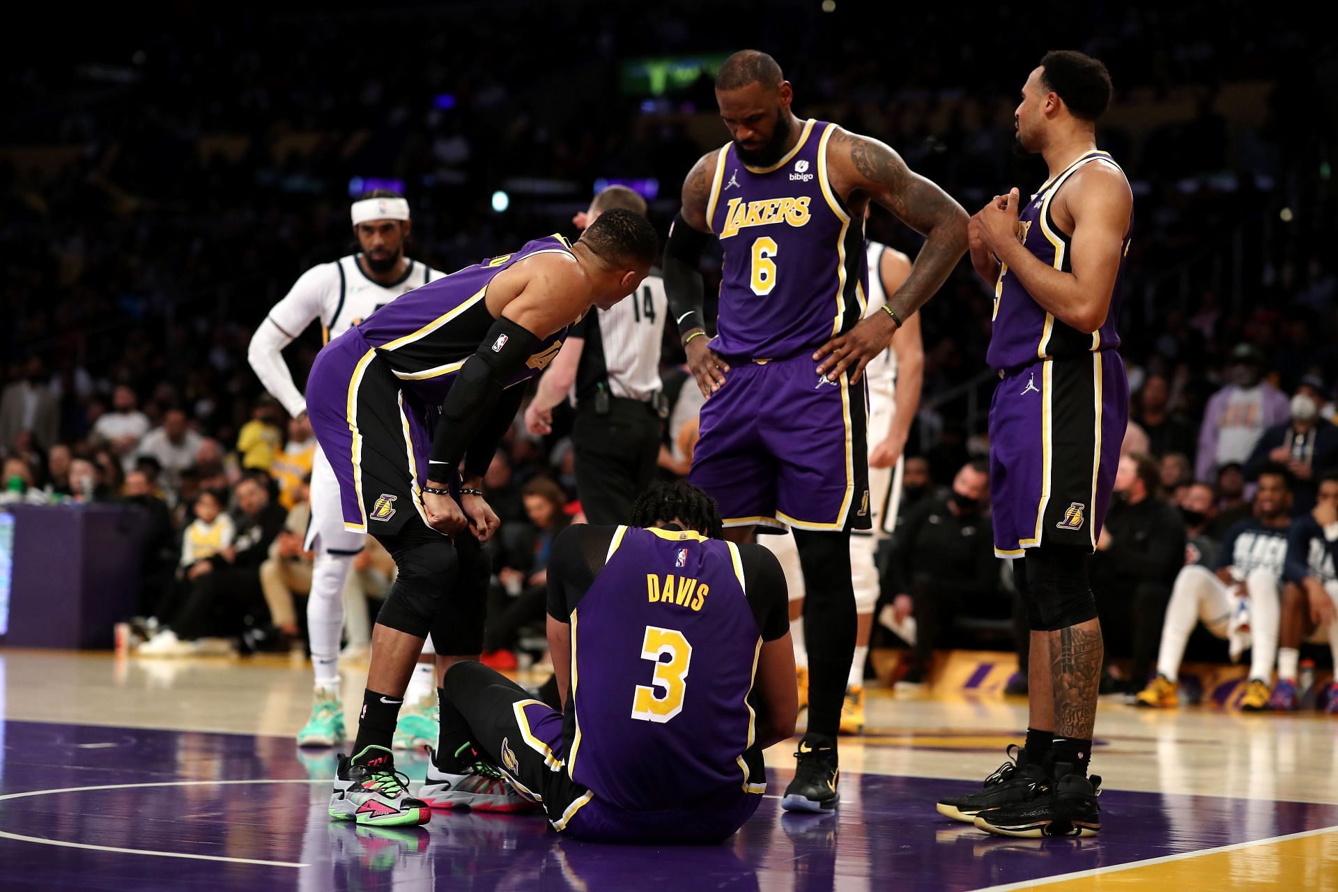 Russell Westbrook and LeBron James of the LA Lakers check on teammate Anthony Davis (#3).