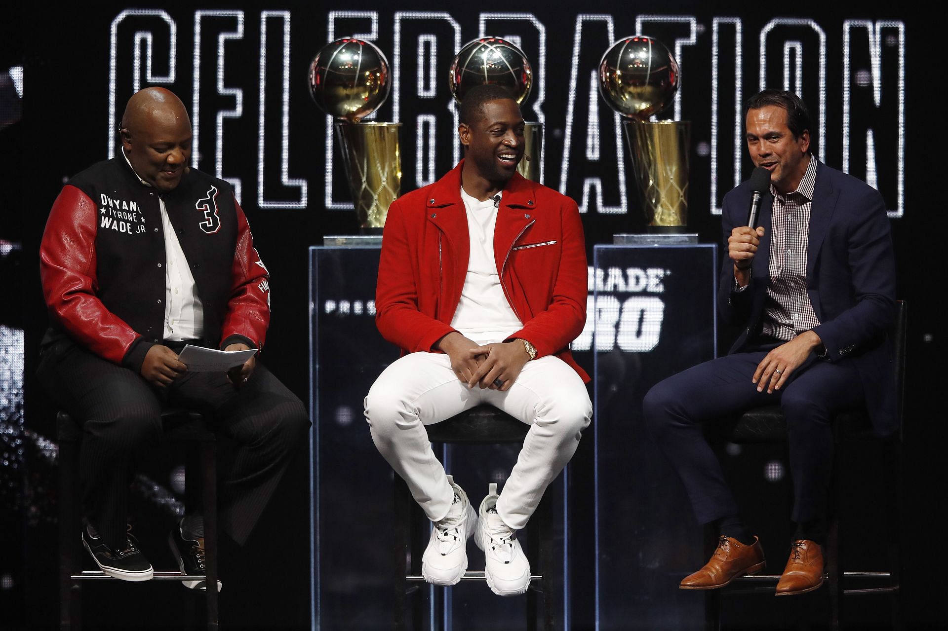 Former Miami Heat player Dwyane Wade laughs with head coach Erik Spoelstra and host Jason Jackson