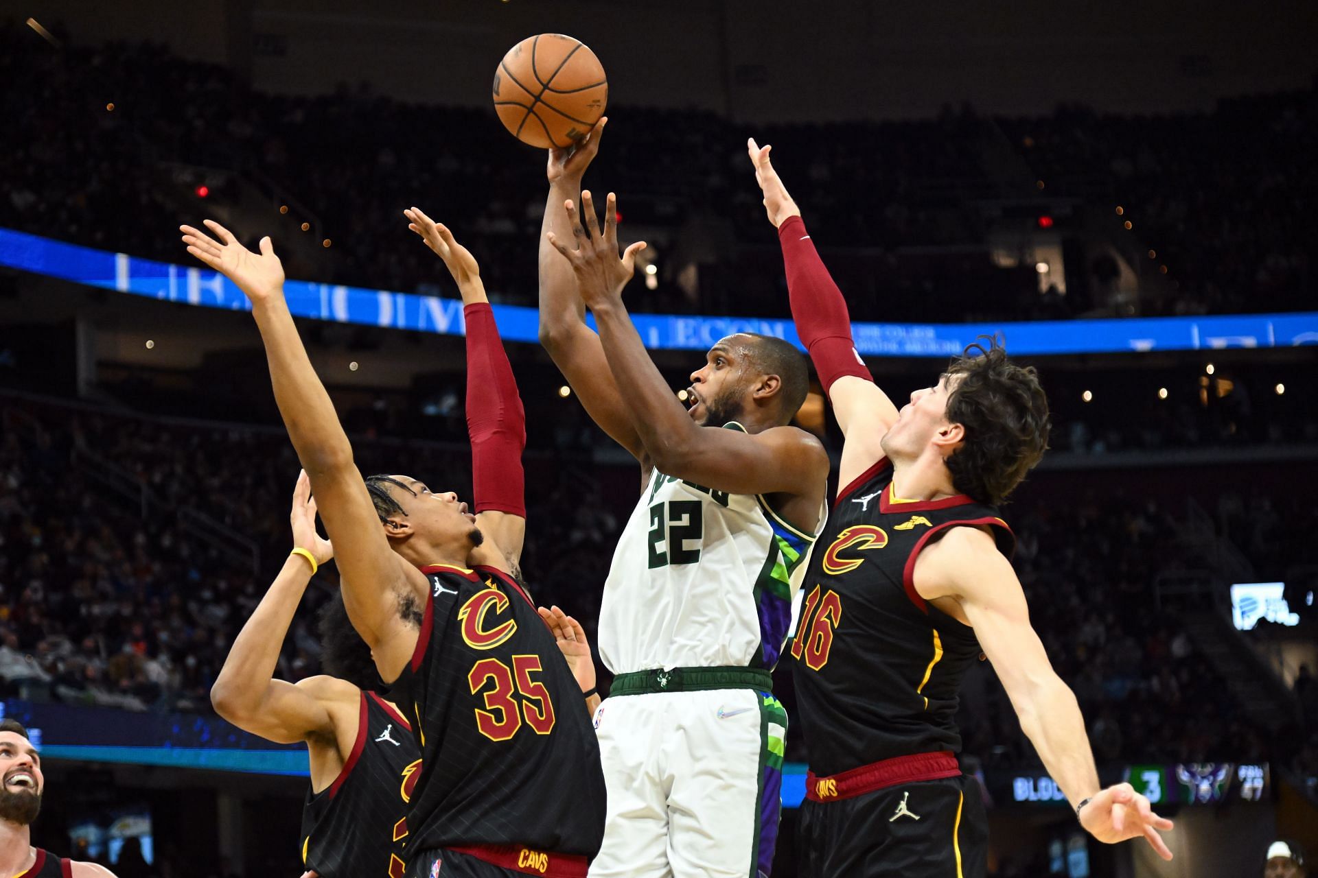 Khris Middleton attempts a tough shot over three defenders