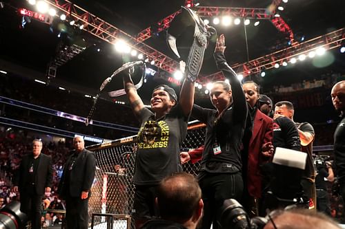 Amanda Nunes celebrating with the women's featherweight and bantamweight championships