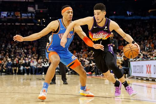 Devin Booker of the Phoenix Suns drives past Darius Bazley of the OKC Thunder