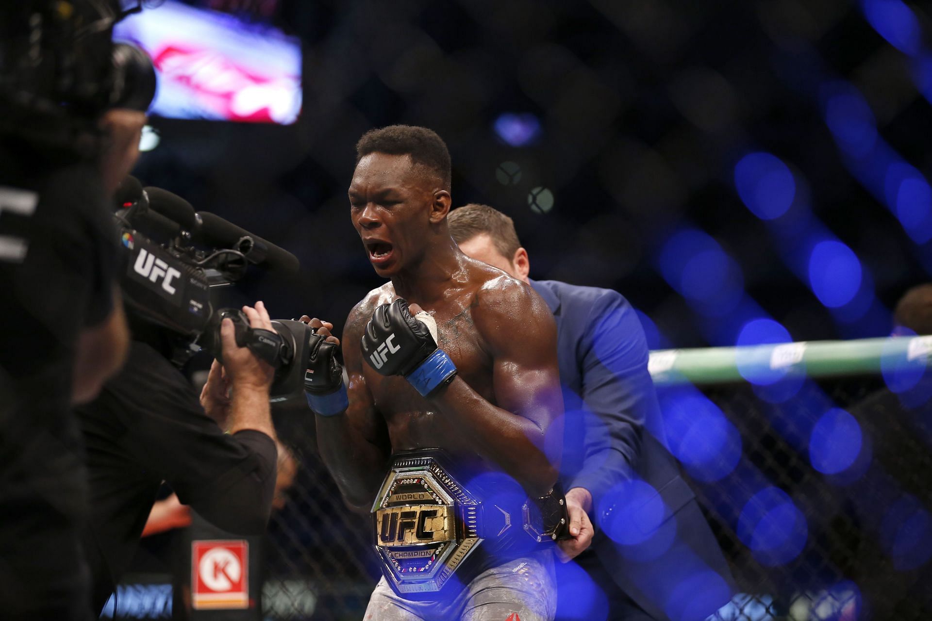 Israel Adesanya celebrates winning the middleweight title at UFC 243