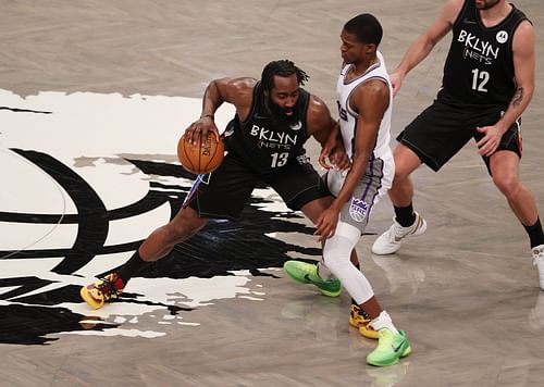 James Harden of the Brooklyn Nets dribbles against De'Aaron Fox of the Sacramento Kings.