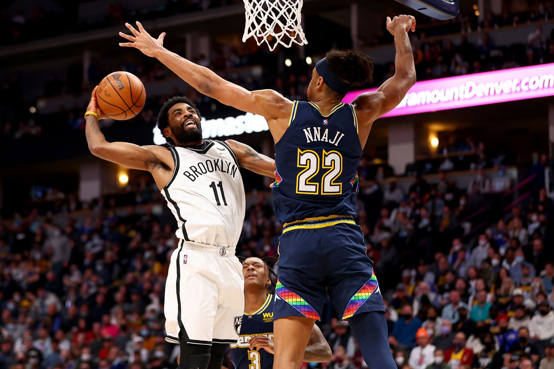 Kyrie Irving attempts to score against Zeke Nnaji.