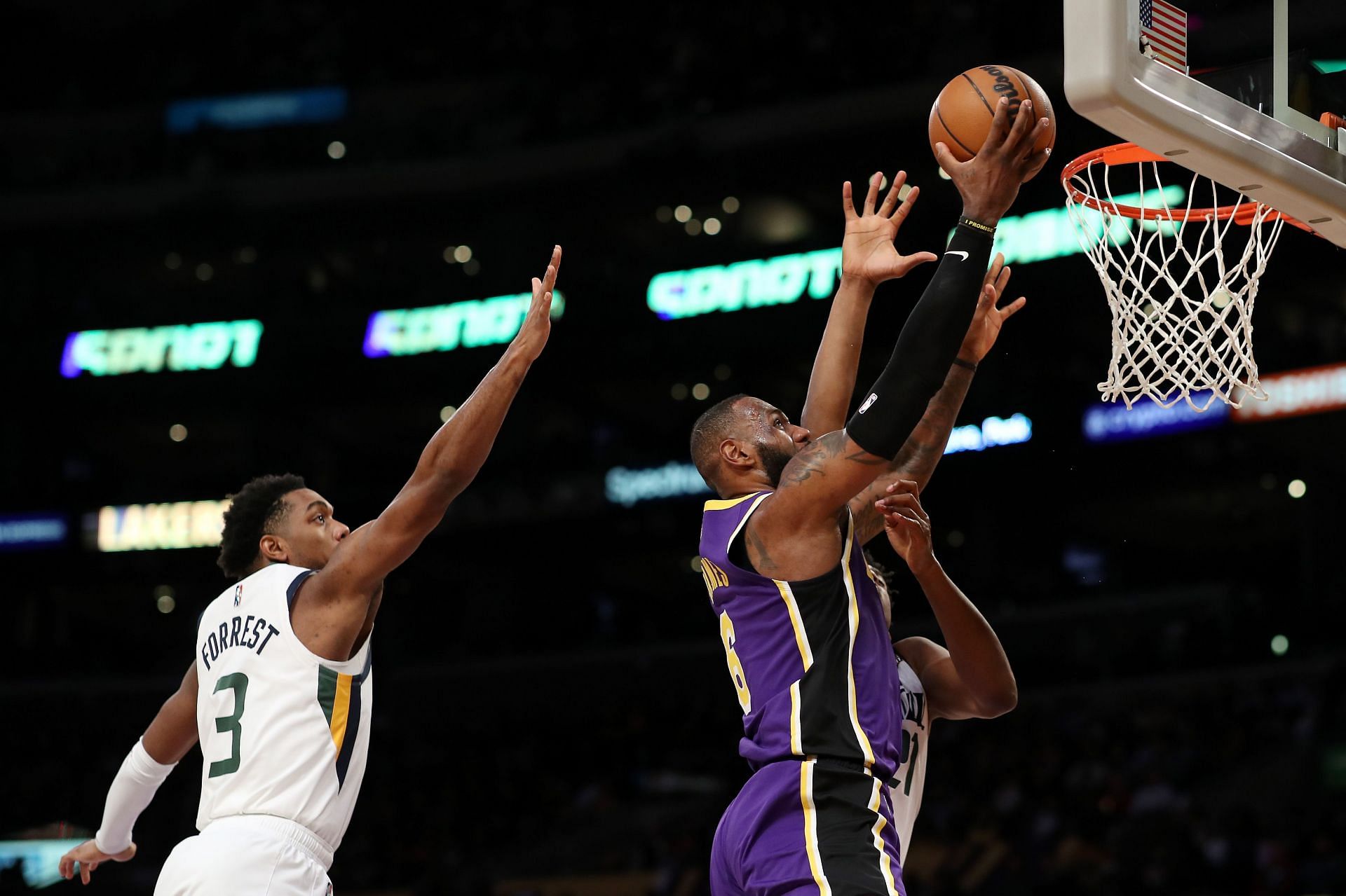 LeBron James of the LA Lakers drives against Hassan Whiteside and Trent Forrest of the Utah Jazz during the second quarter at Crypto.com Arena on Wednesday in Los Angeles, California.