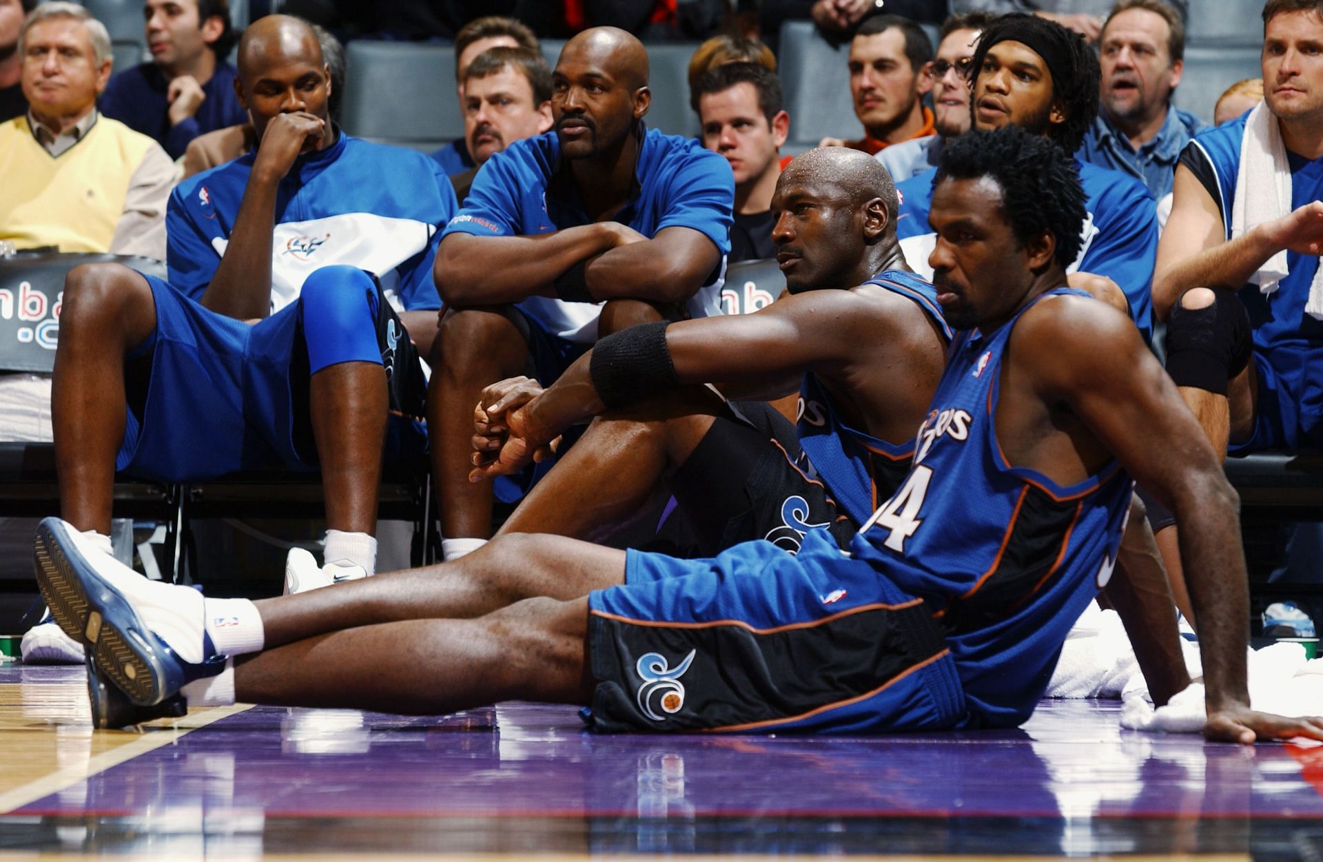 Michael Jordan and Charles Oakley, foreground, sit on the sideline.