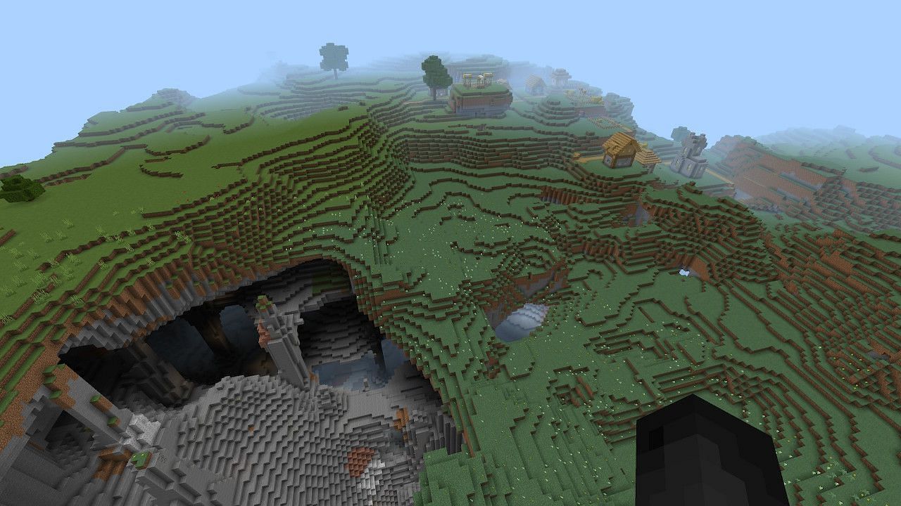 A village next to a gigantic pit makes for some good enviornmental storytelling and a great place to build up a world (Image via Minecraft)