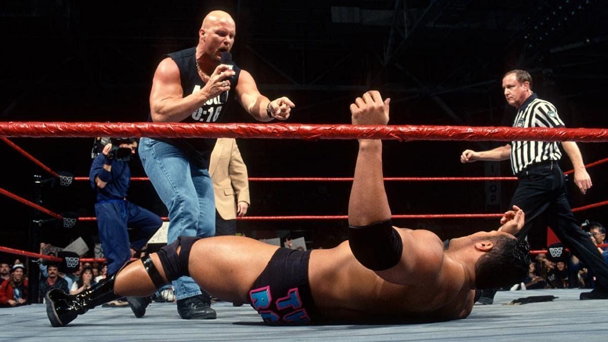 Stone Cold hits the Rock with a Stunner after awarding him the Intercontinental title