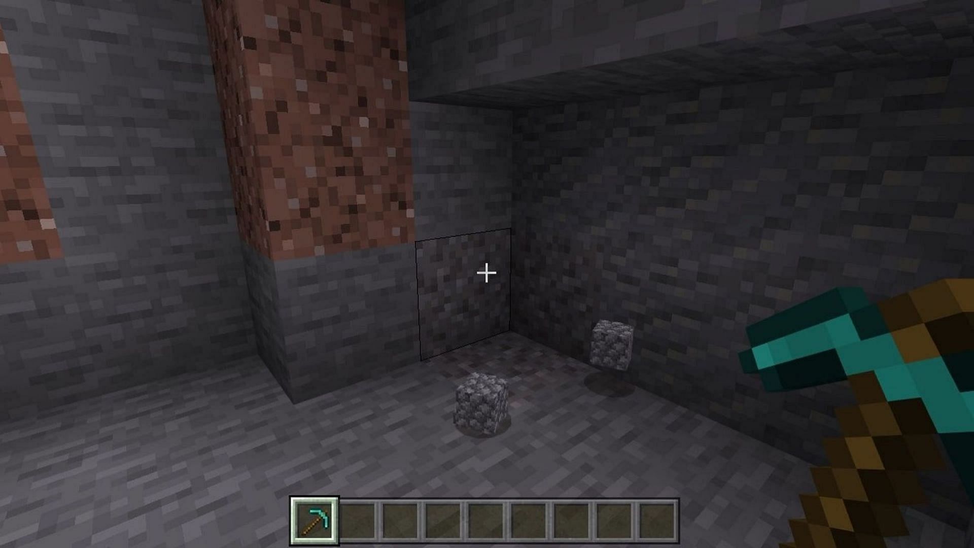 A player mines cobblestone from a nearby hill (Image via Mojang)