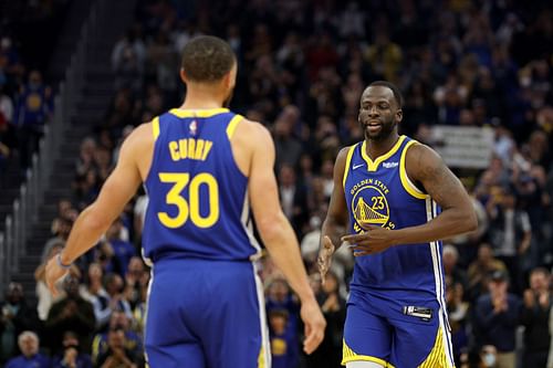 Draymond Green #23 of the Golden State Warriors is welcomed by Steph Curry #30 after he checked in to the game for the first time after returning from an injury in the first quarter of their game against the Washington Wizards at Chase Center on March 14, 2022 in San Francisco, California.