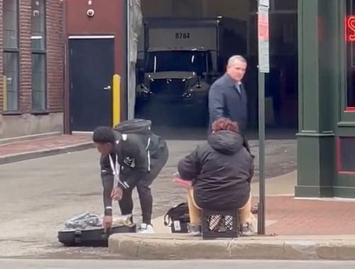 Malik Willis (L) giving Nike gear to homeless person