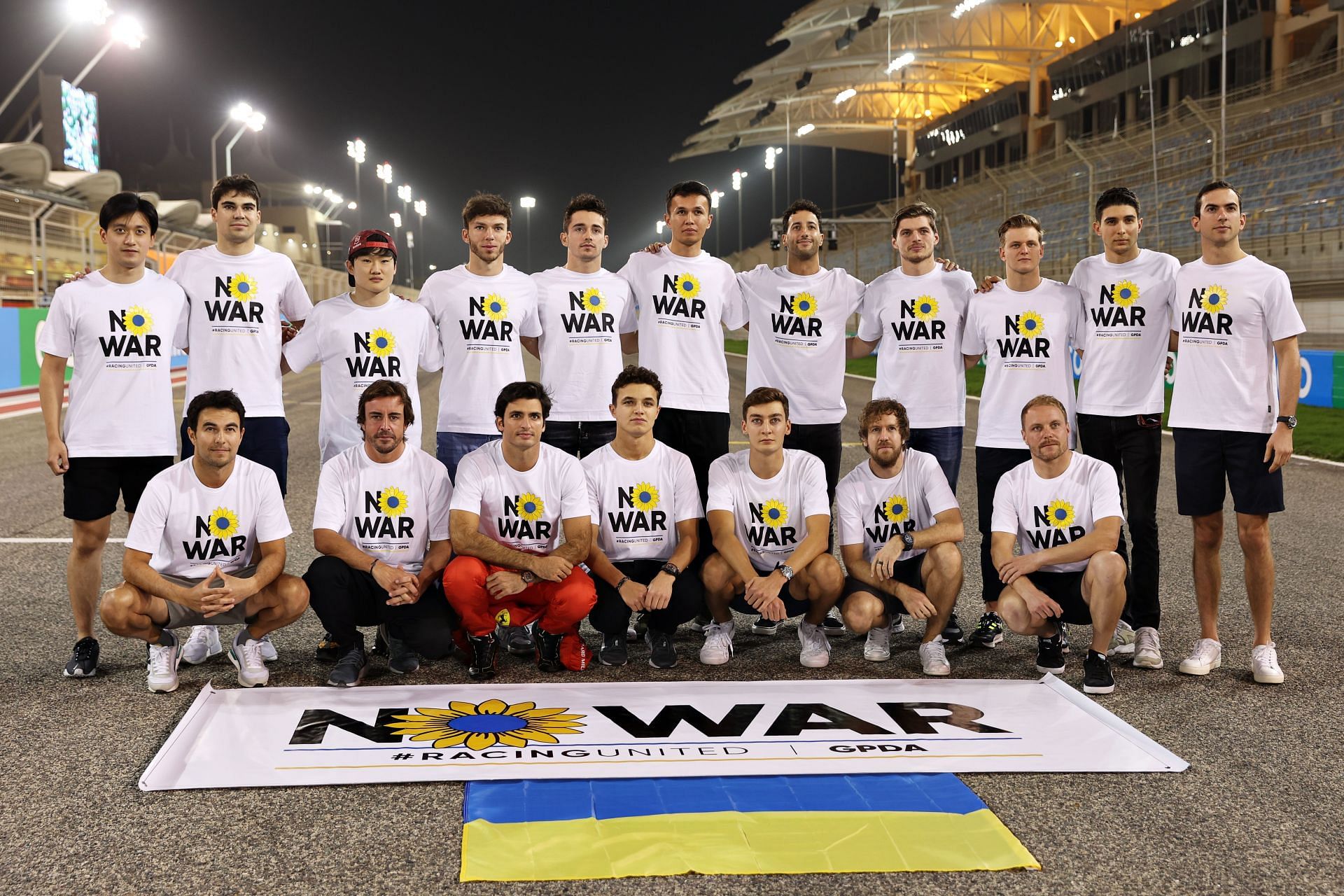 F1 drivers pose with a banner promoting peace and sympathy with Ukraine before F1 Testing in Bahrain (Photo by Mark Thompson/Getty Images)