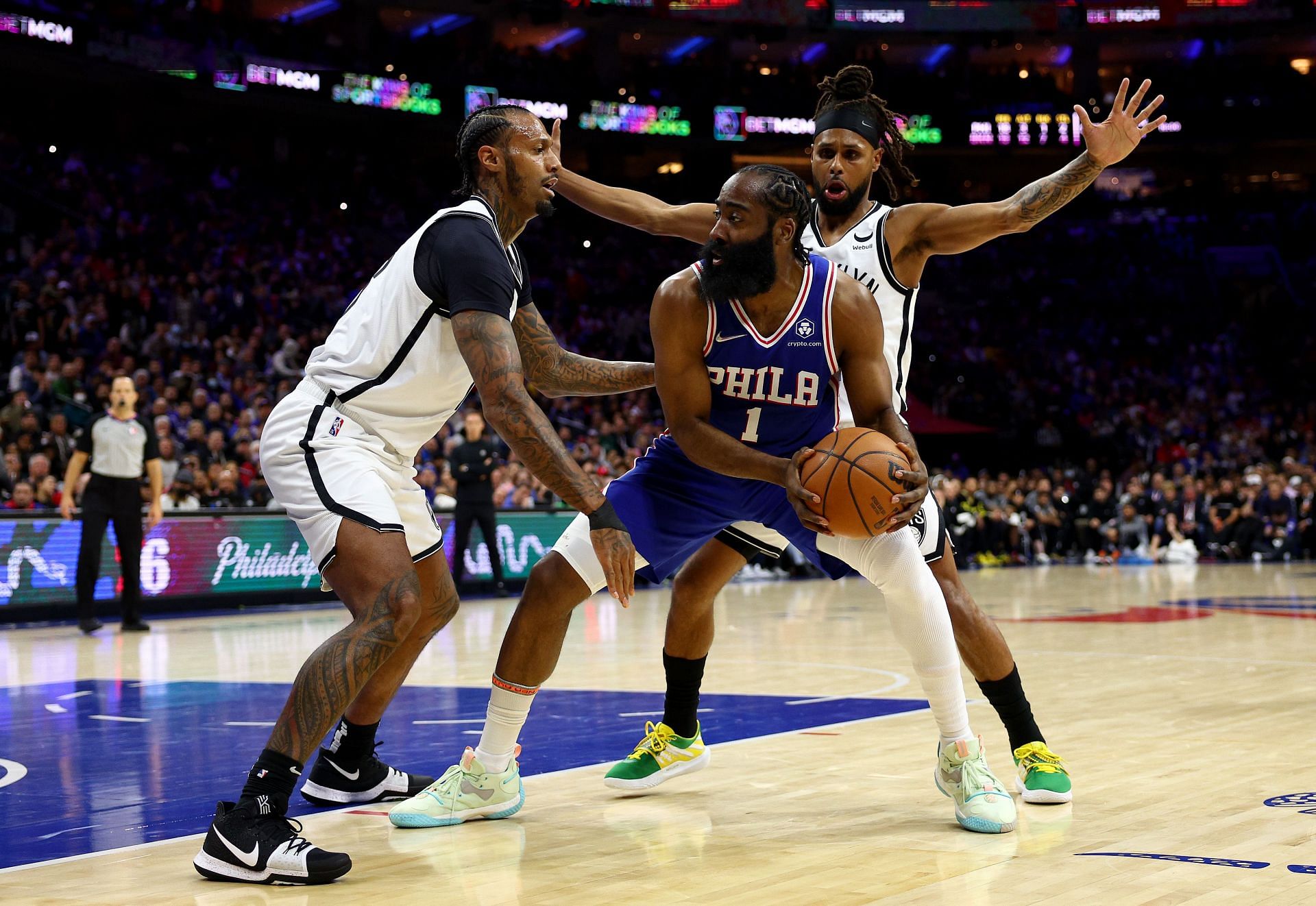 James Harden of the Philadelphia 76ers is surrounded by James Johnson and Patty Mills of the Brooklyn Nets in the first half at Wells Fargo Center on Thursday in Philadelphia, Pennsylvania.