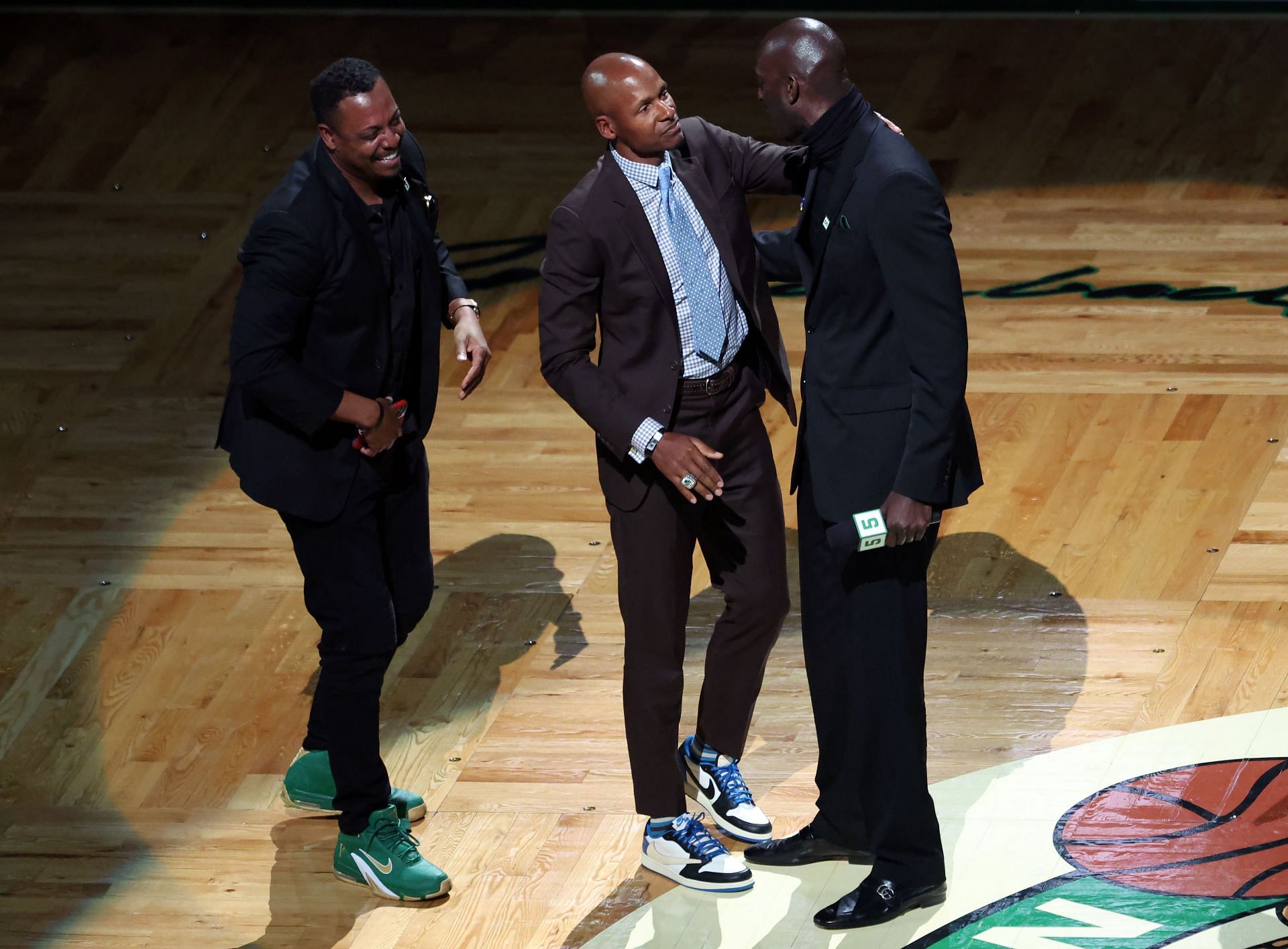 Former Boston Celtics players Paul Pierce, left, and Ray Allen, middle, hug Kevin Garnett during his number retirement ceremony following the game between the Boston Celtics and the Dallas Mavericks at TD Garden on Sunday in Boston, Massachusetts