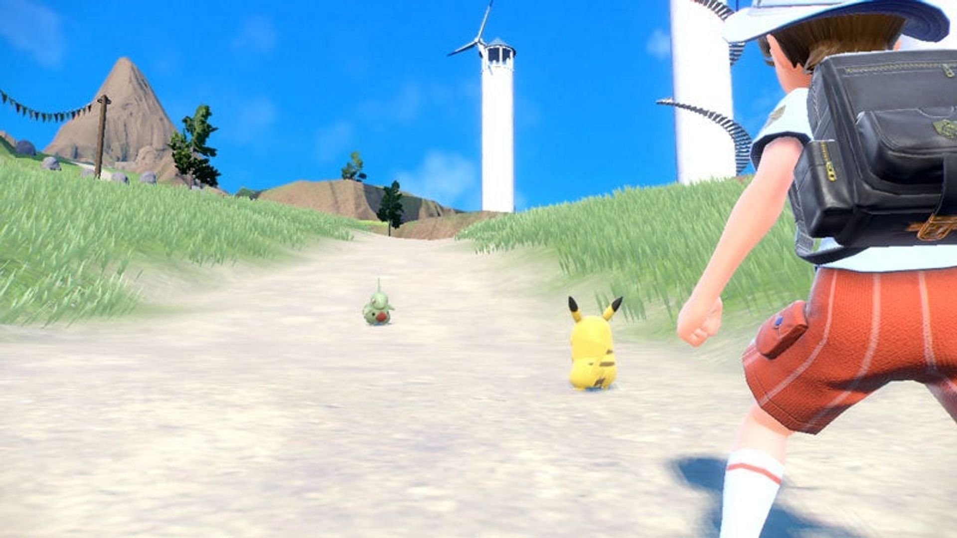 A player batting a wild Larvitar in Pokemon Scarlet (Image via The Pokemon Company)