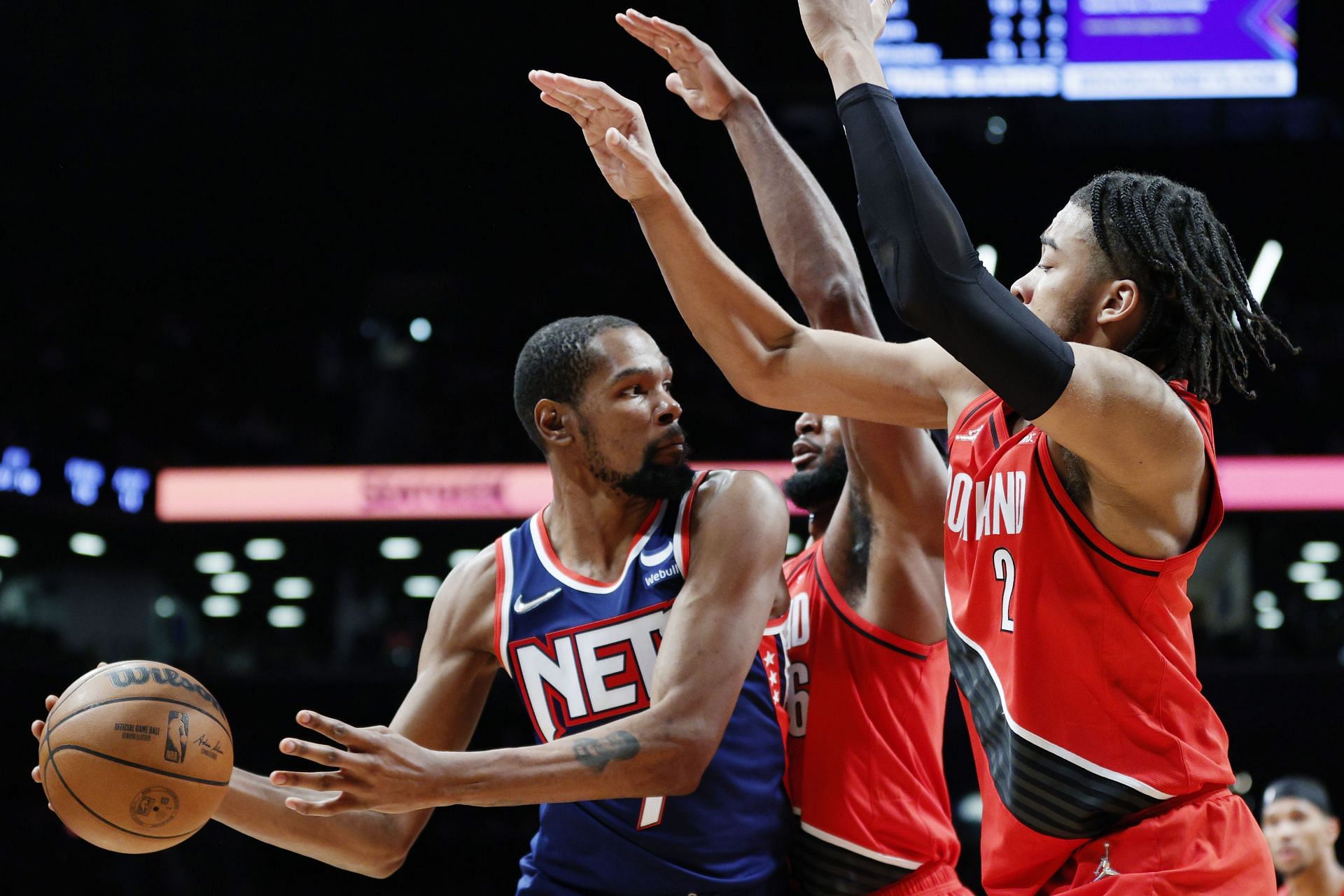 Kevin Durant of the Brooklyn Nets looks to pass against Justise Winslow and Trendon Watford of the Portland Trail Blazers on Friday in the Brooklyn borough of New York City.