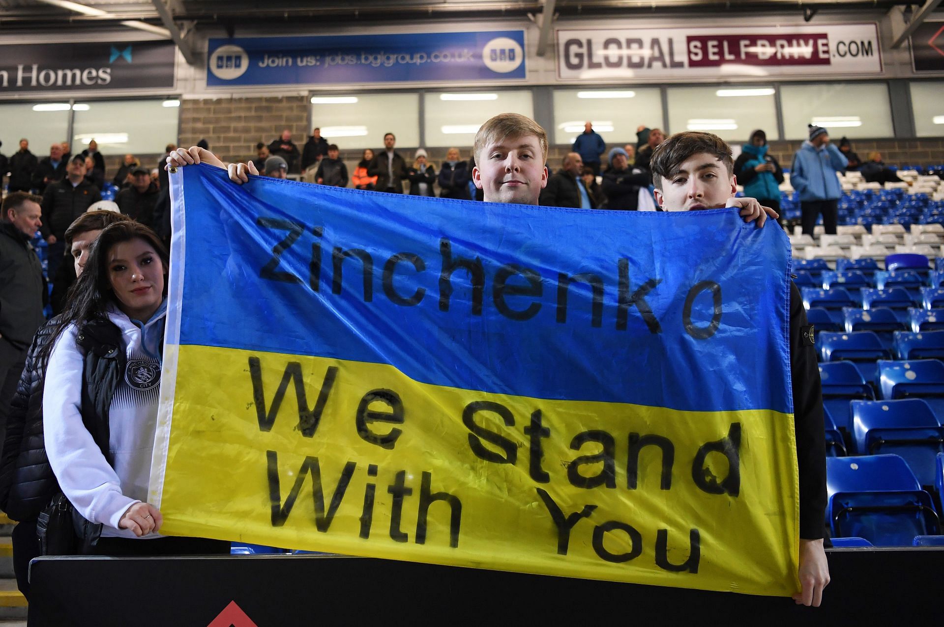 Manchester City fans hold a flag with a message of support for Oleksandr Zinchenko