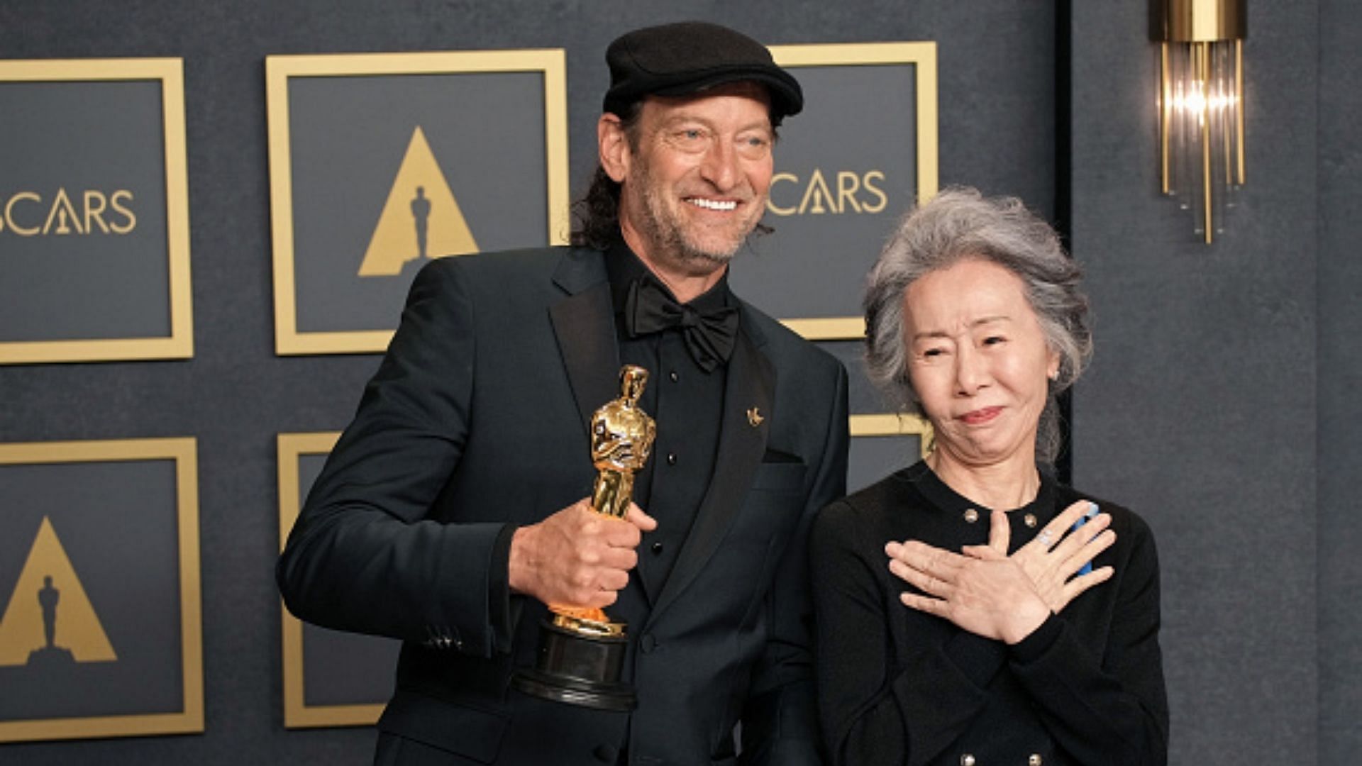 Troy Kotsur and Youn Yuh-jung pose in the press room during the 94th Annual Academy Awards (Image via Jeff Kravtiz/Getty Images)