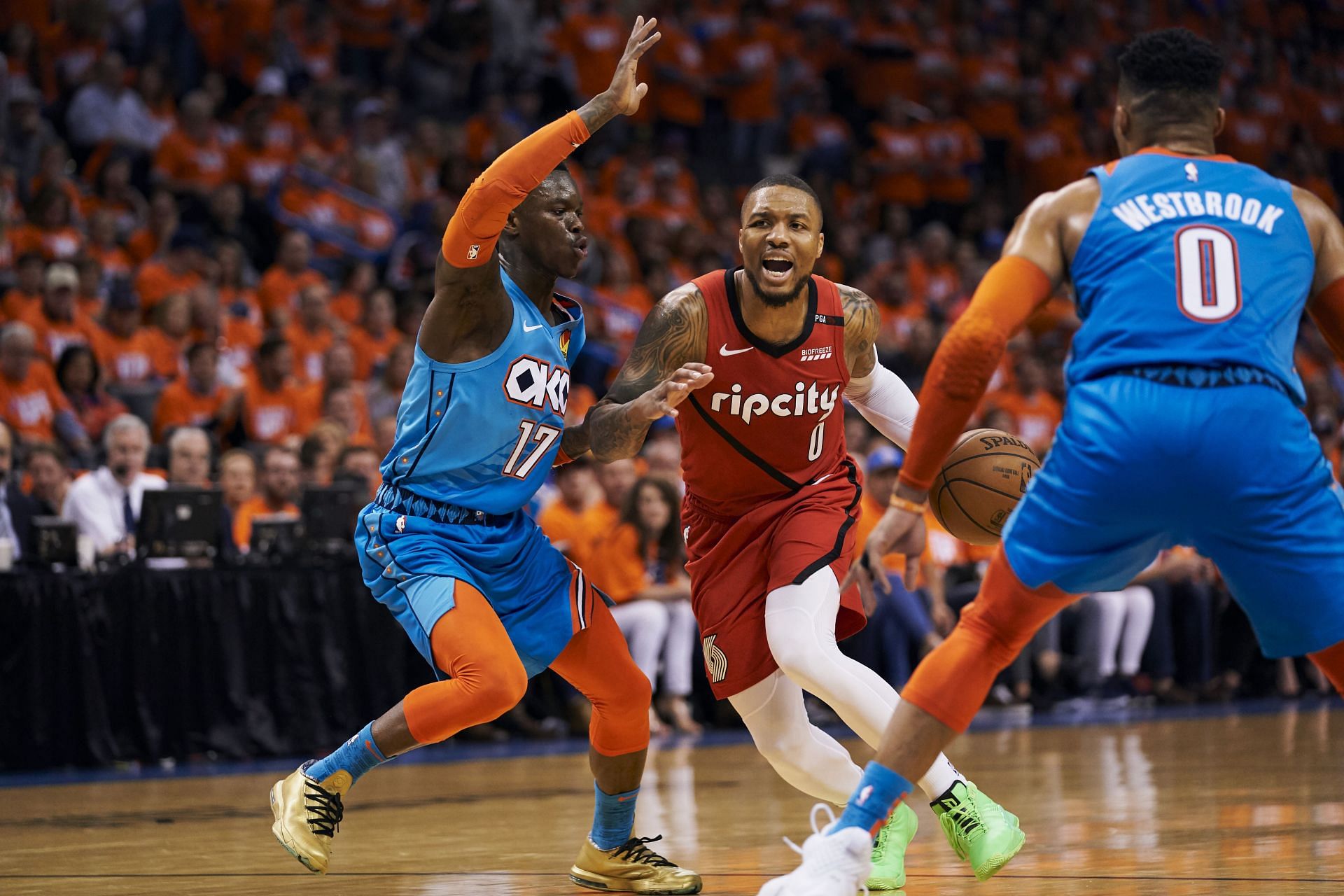 Damian Lillard #0 of the Portland Trail Blazers drives to the basket against Dennis Schroder #17 and Russell Westbrook #0 of the Oklahoma City Thunder during the first half of game three of the Western Conference quarterfinals at Chesapeake Energy Arena on April 19, 2019 in Oklahoma City, Oklahoma.