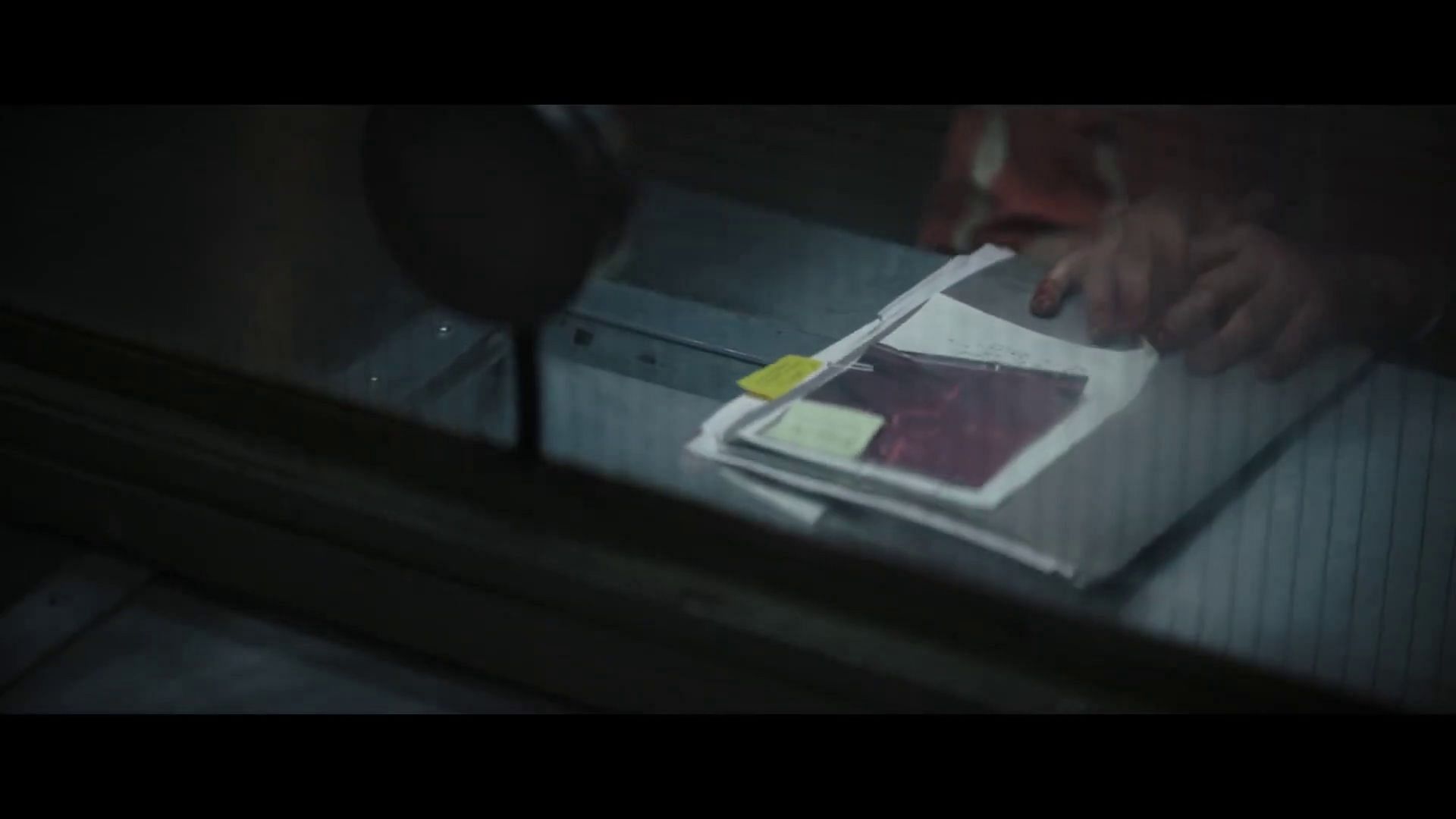 Batman hands him case files about The Riddler (Image via Warner Bros.)