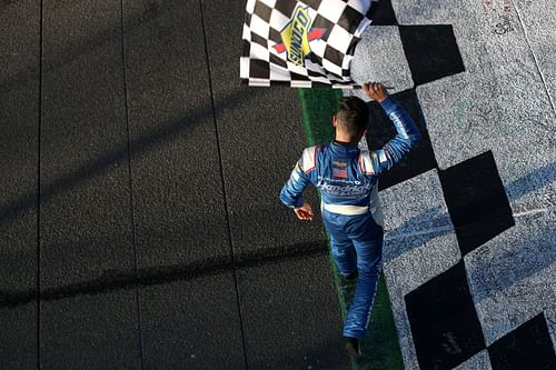 Kyle Larson celebrates with the checkered flag after winning the WISE Power 400 at Auto Club Speedway.