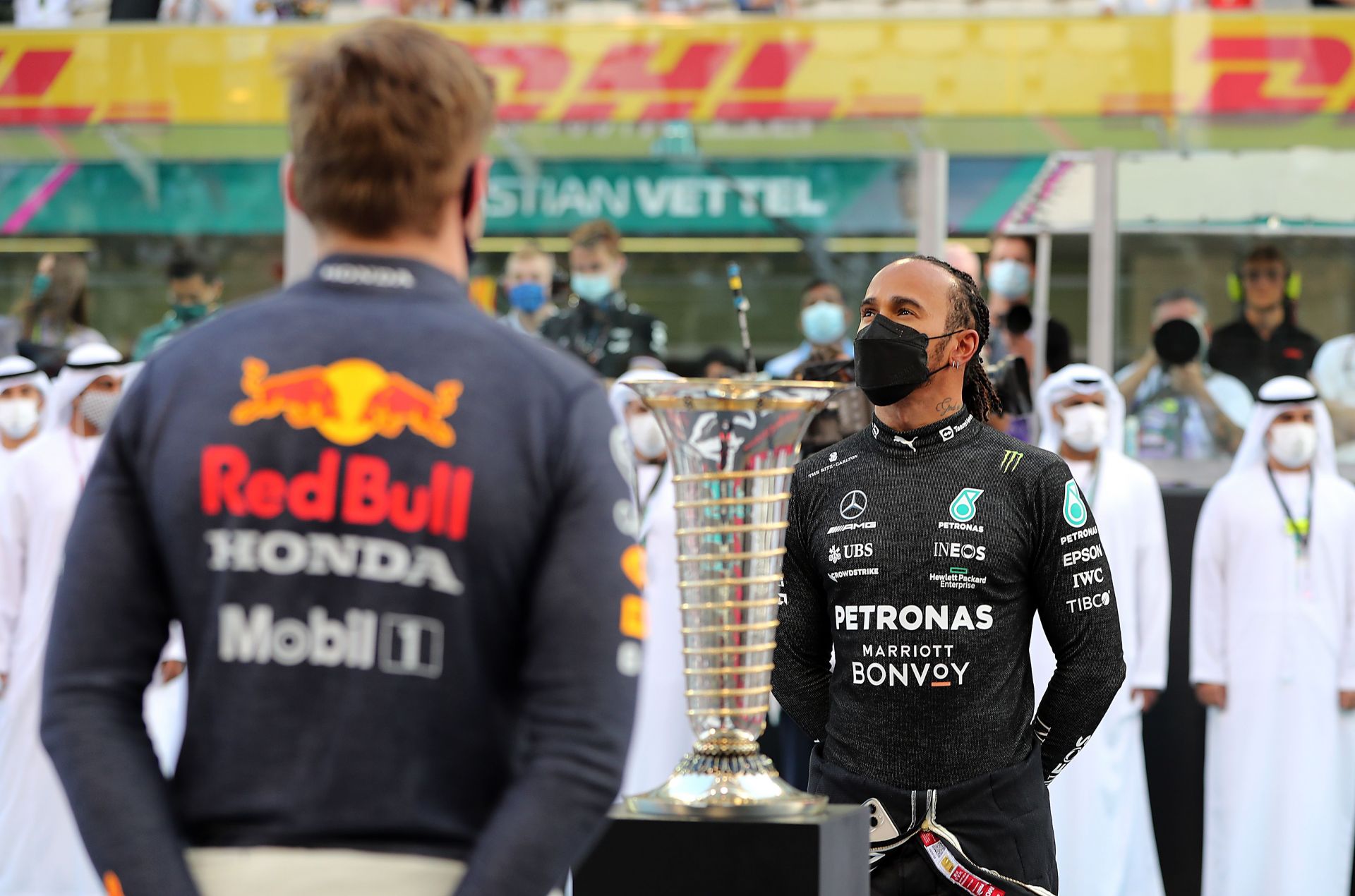 Championship contenders Max Verstappen and Lewis Hamilton stand in front of the F1 World Drivers Championship Trophy on the grid before the 2021 Abu Dhabi Grand Prix (Photo by Kamran Jebreili - Pool/Getty Images)