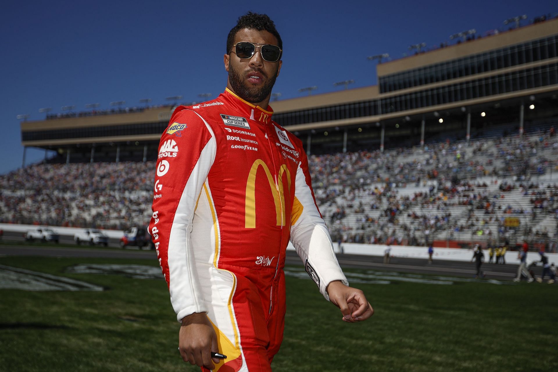 Bubba Wallace walks through the infield grass before the NASCAR Cup Series Folds of Honor QuikTrip 500 at Atlanta Motor Speedway