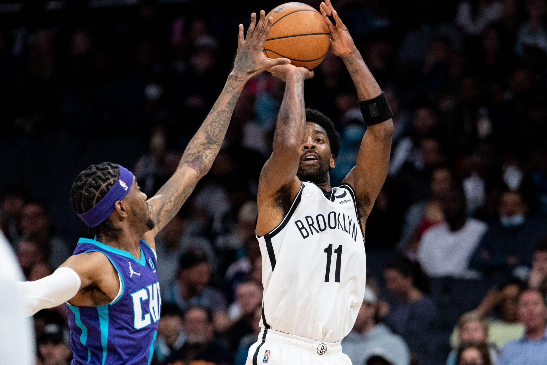 Kyrie Irving of the Brooklyn Nets shoots over Jalen McDaniels of the Charlotte Hornets