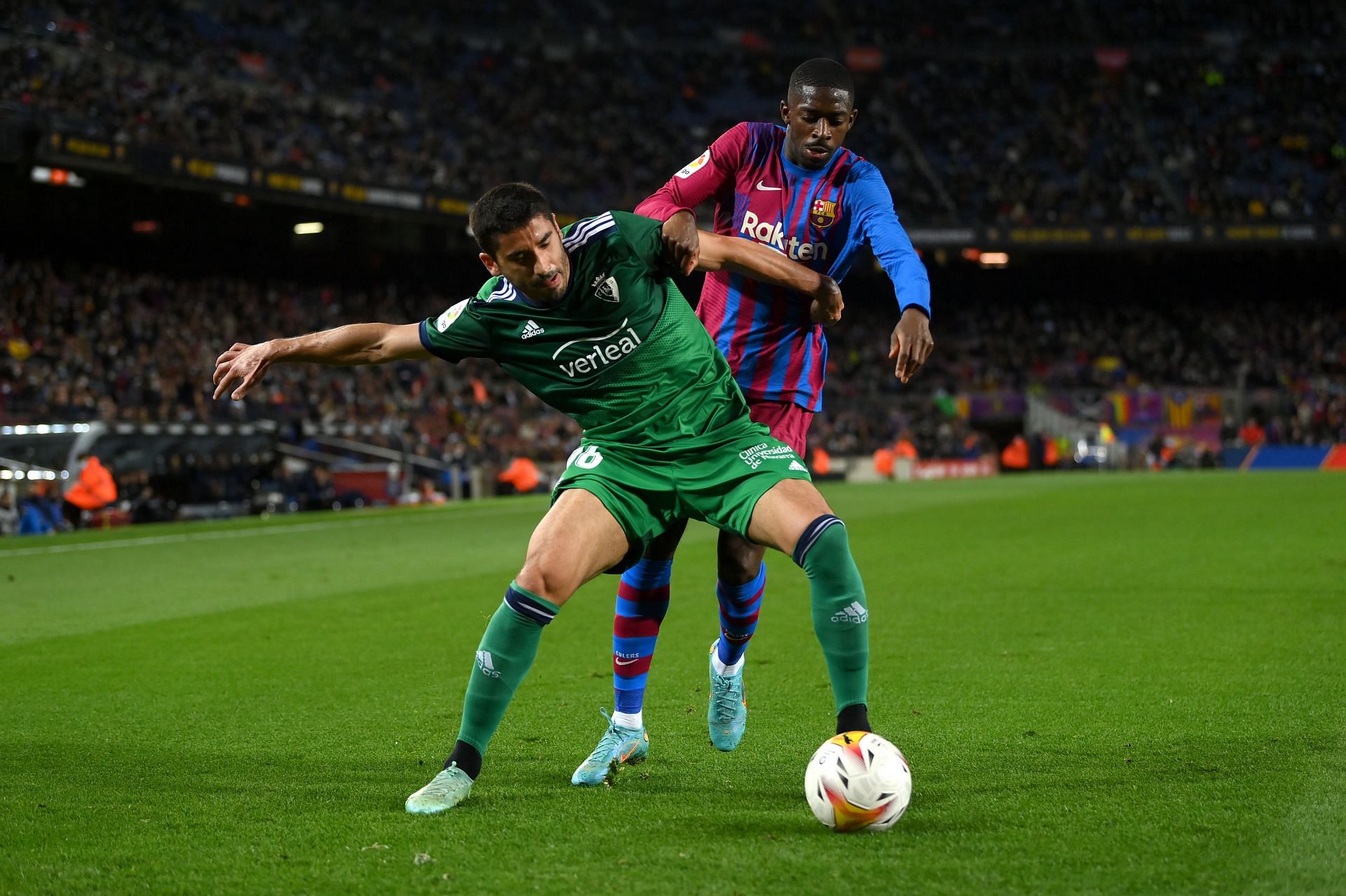 Ousmane Dembele tussles it out with Jose Angel.