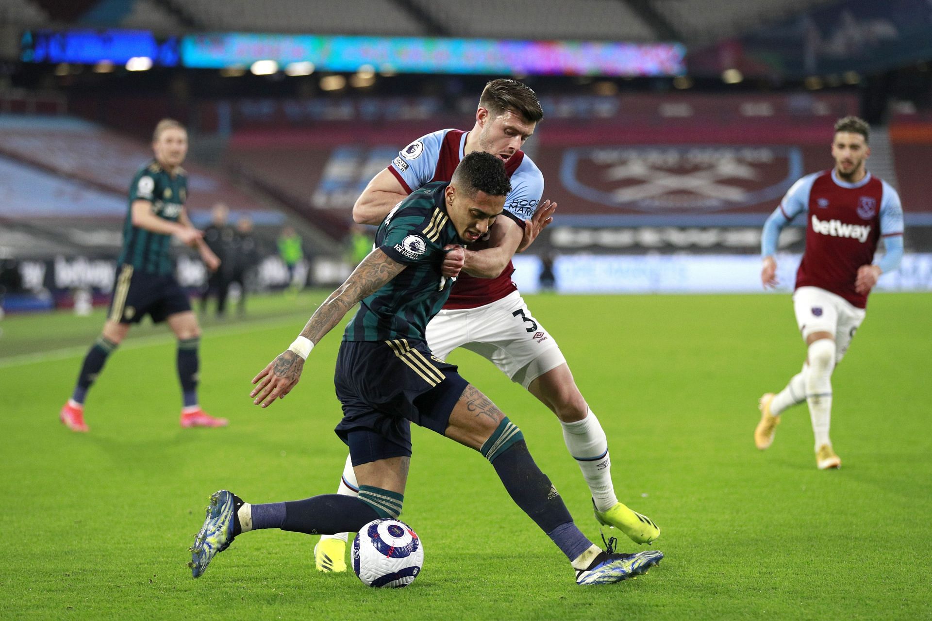 Aaron Cresswell (#3) grapples with Raphinha during the Leeds-West Ham game
