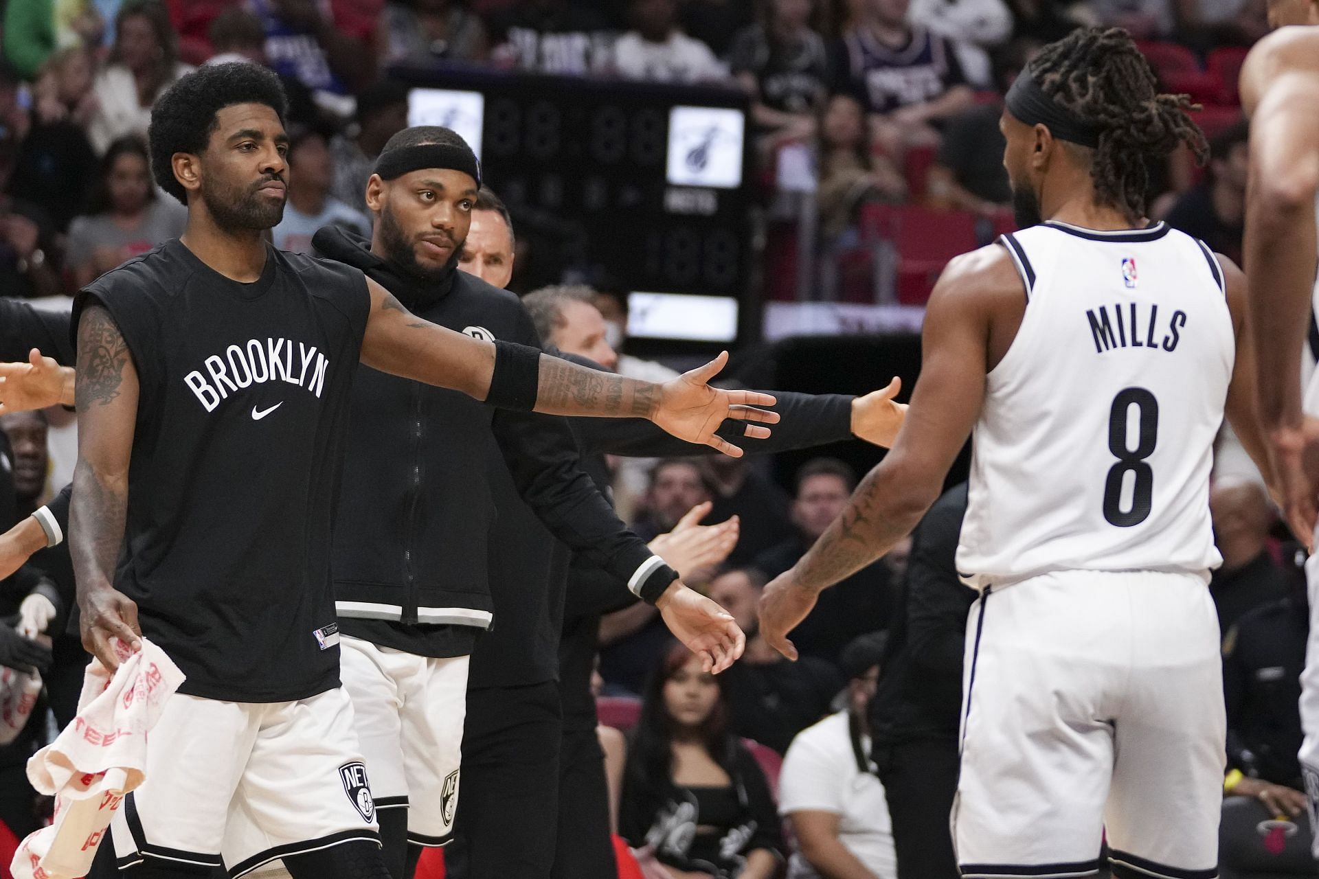 Kyrie Irving, left, and Bruce Brown shake hands with Patty Mills of the Brooklyn Nets.