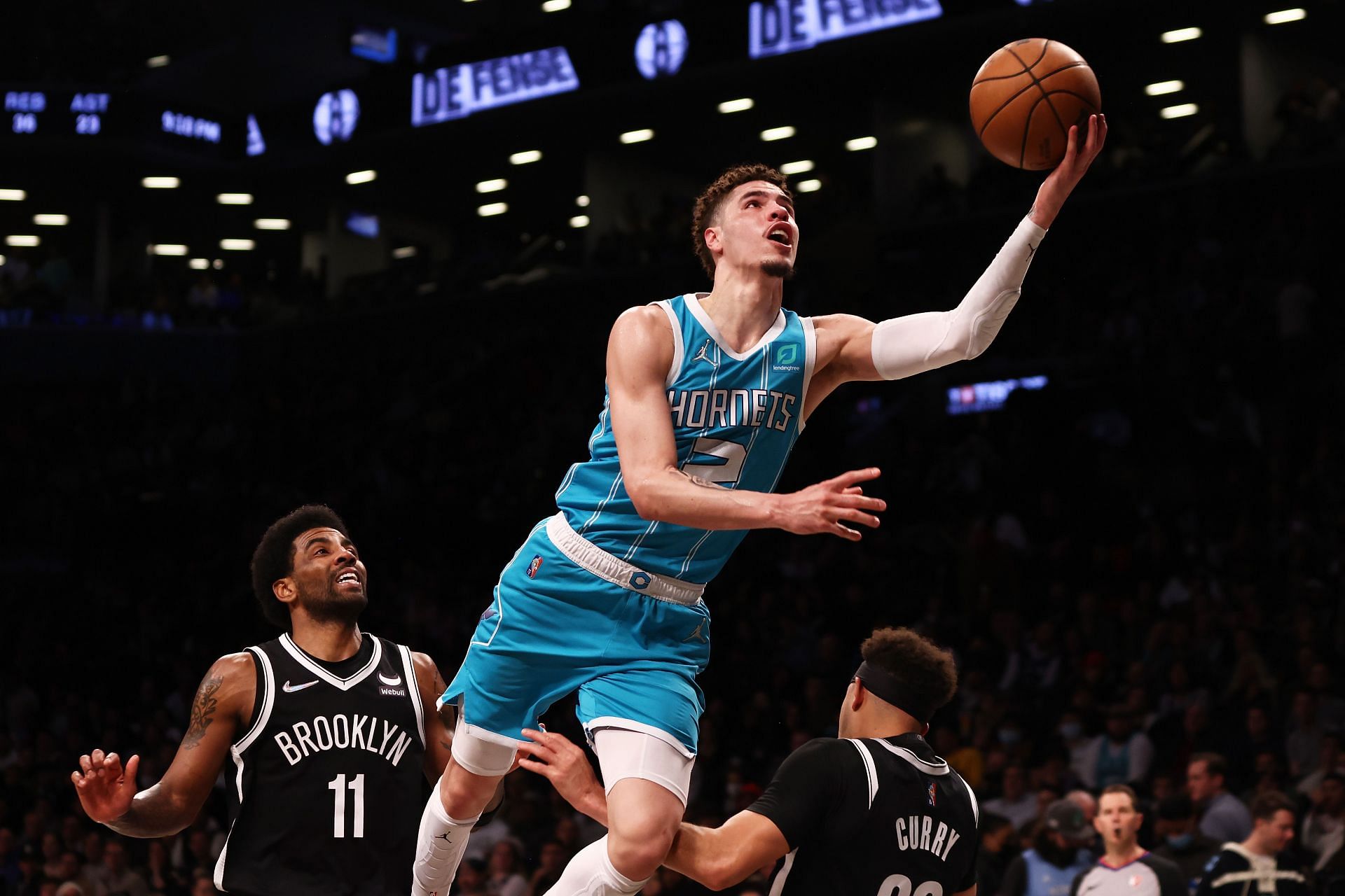 LaMelo Ball of the Charlotte Hornets drives to the basket against Kyrie Irving (11) of the Brooklyn Nets at Barclays Center on Sunday in New York City.