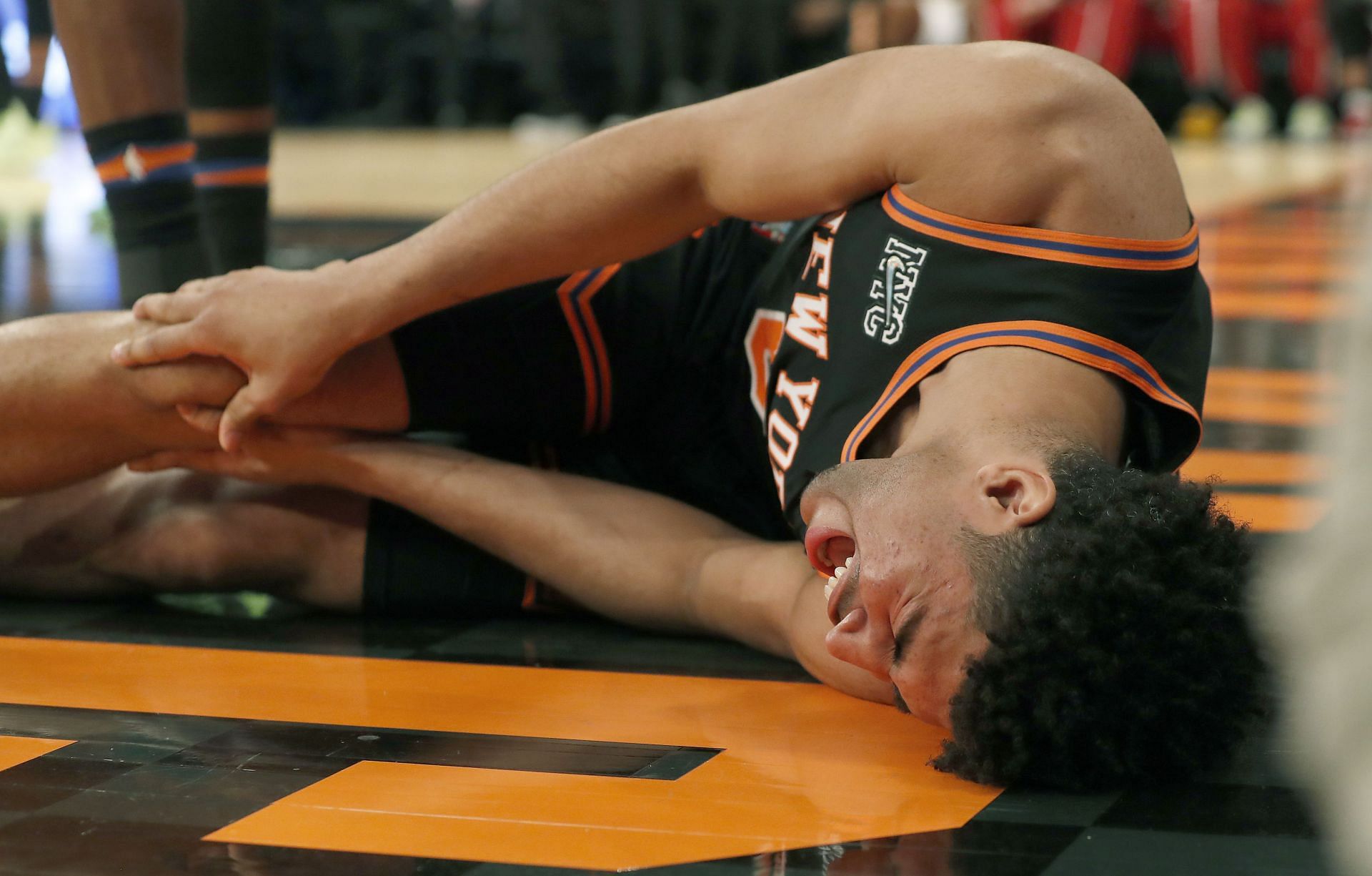 Quentin Grimes of the New York Knicks grimaces after an injury to his knee